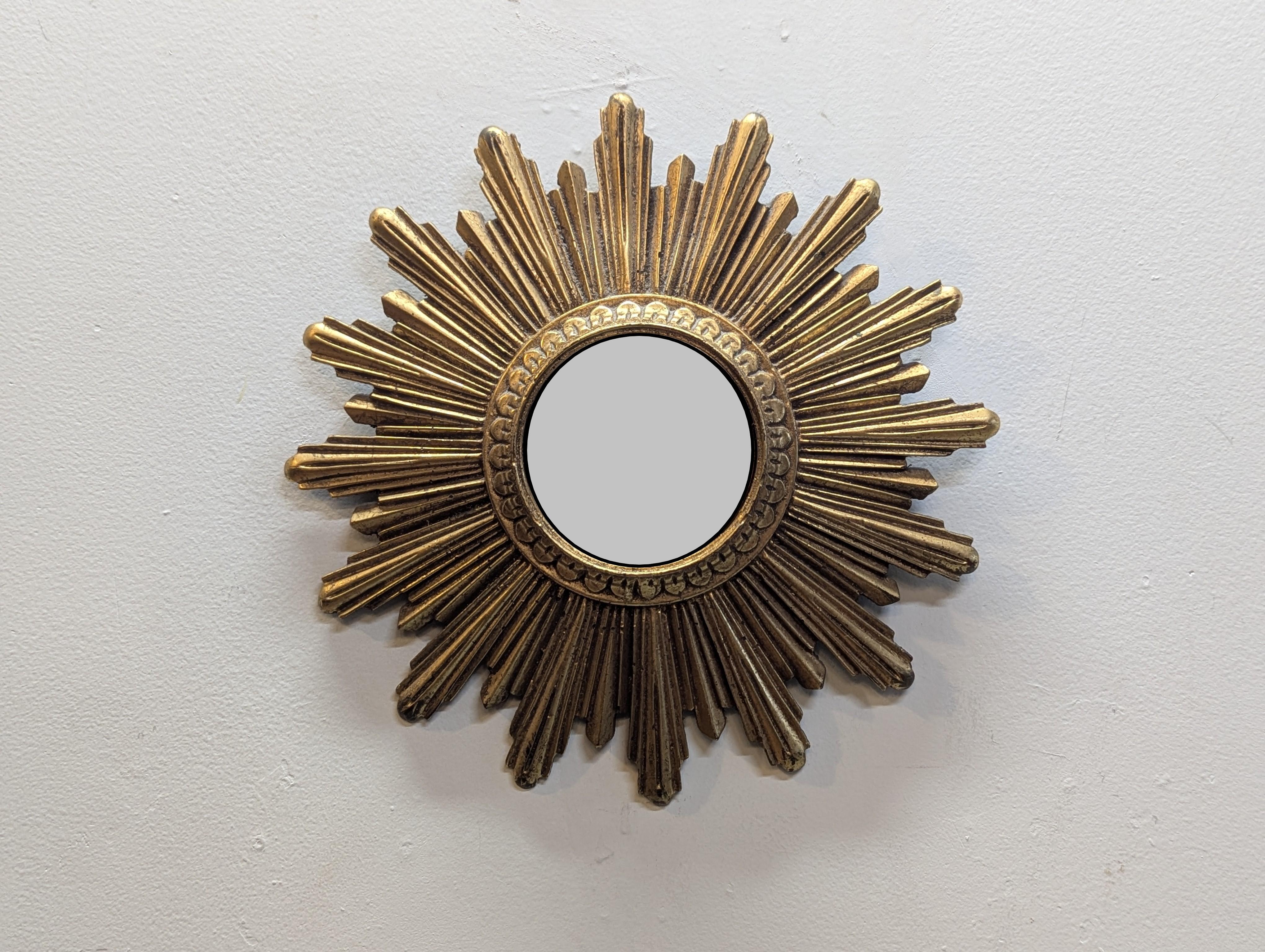 French Mid Century Convex Sunburst Mirror.  Collectable Mid Century miniature Convex Sunburst Mirror.  Made of gilt composite - resin, small size this mirror has a significant presence somewhat ecclesiastic in style.  These miniature mirrors are