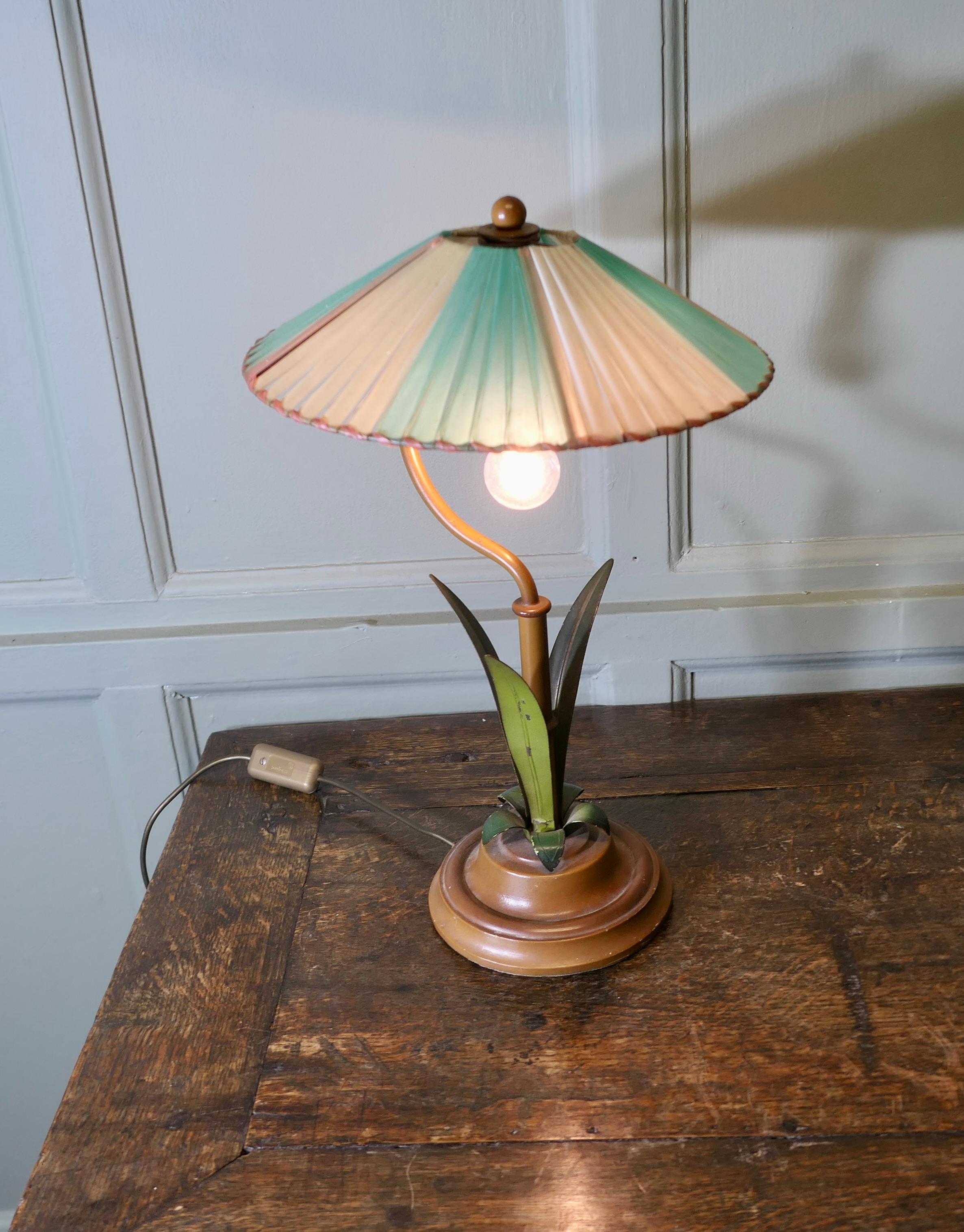 Lampe à poser Kitsch du milieu du siècle

Il s'agit d'une pièce unique très intéressante. La lampe n'est pas très haute, mais elle est très attrayante, elle est ornée de feuilles de palmier vertes en tolewear.
et un parasol en plastique tressé
La