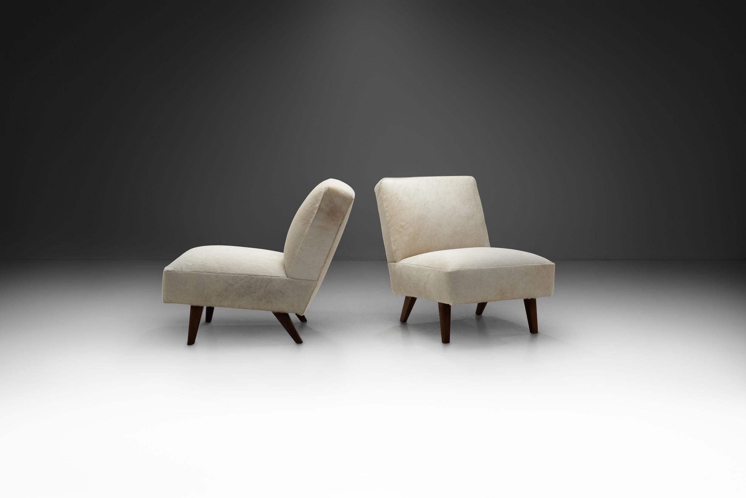 This elegant pair of lounge chairs is an interesting bridge between the 20th century’s earlier artistic movements, like Art Deco, and the modernist movement that was about to shape much of Europe’s furniture design for the following