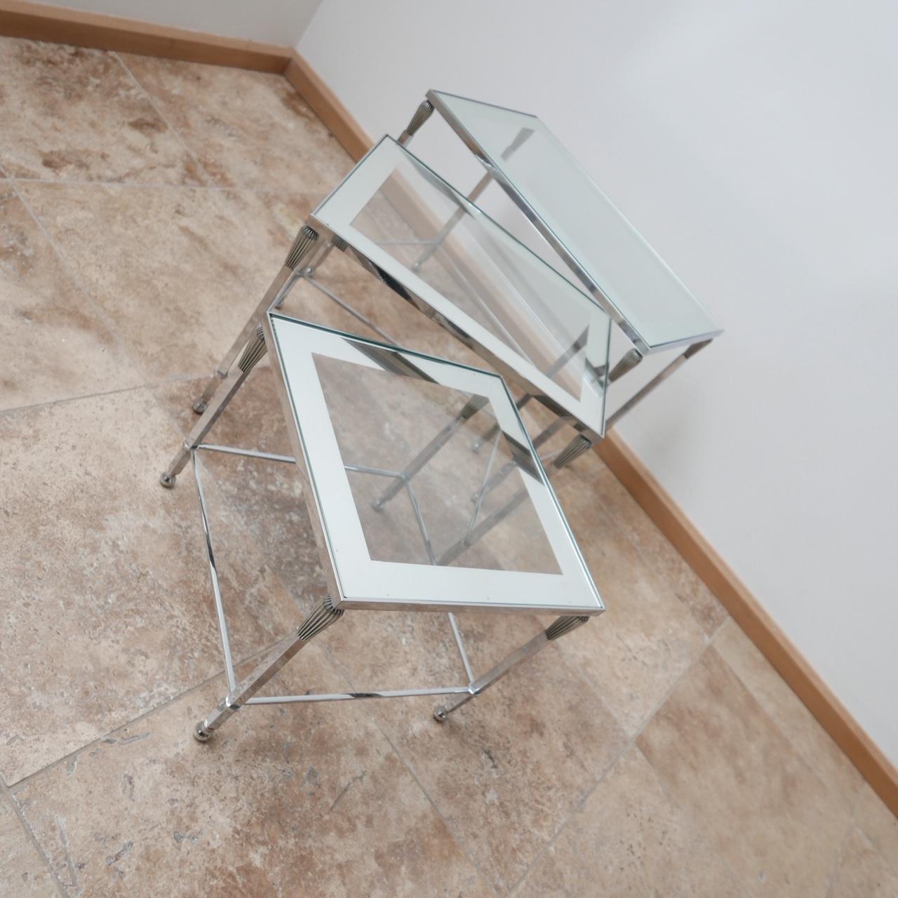 A set of three nesting tables, that are perfect occasional side tables either nested or scattered over a lounge. 

French, circa 1970s. 

The glass has a mirrored outside that provides a nice detailing. 

In good condition, stylish and