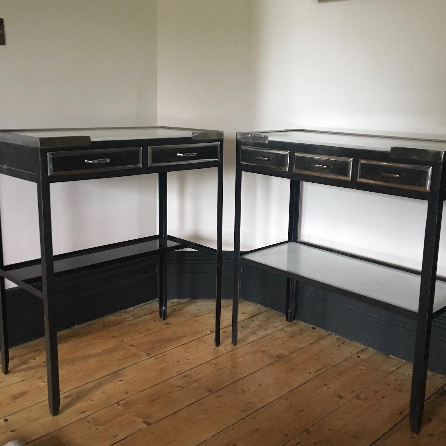 We have two of these medical tables and they are great as a pair even though there are differences in size. Very striking in a bathroom, as console or bedside tables. The one listed here has two glass lined drawers, a milk glass top and black glass