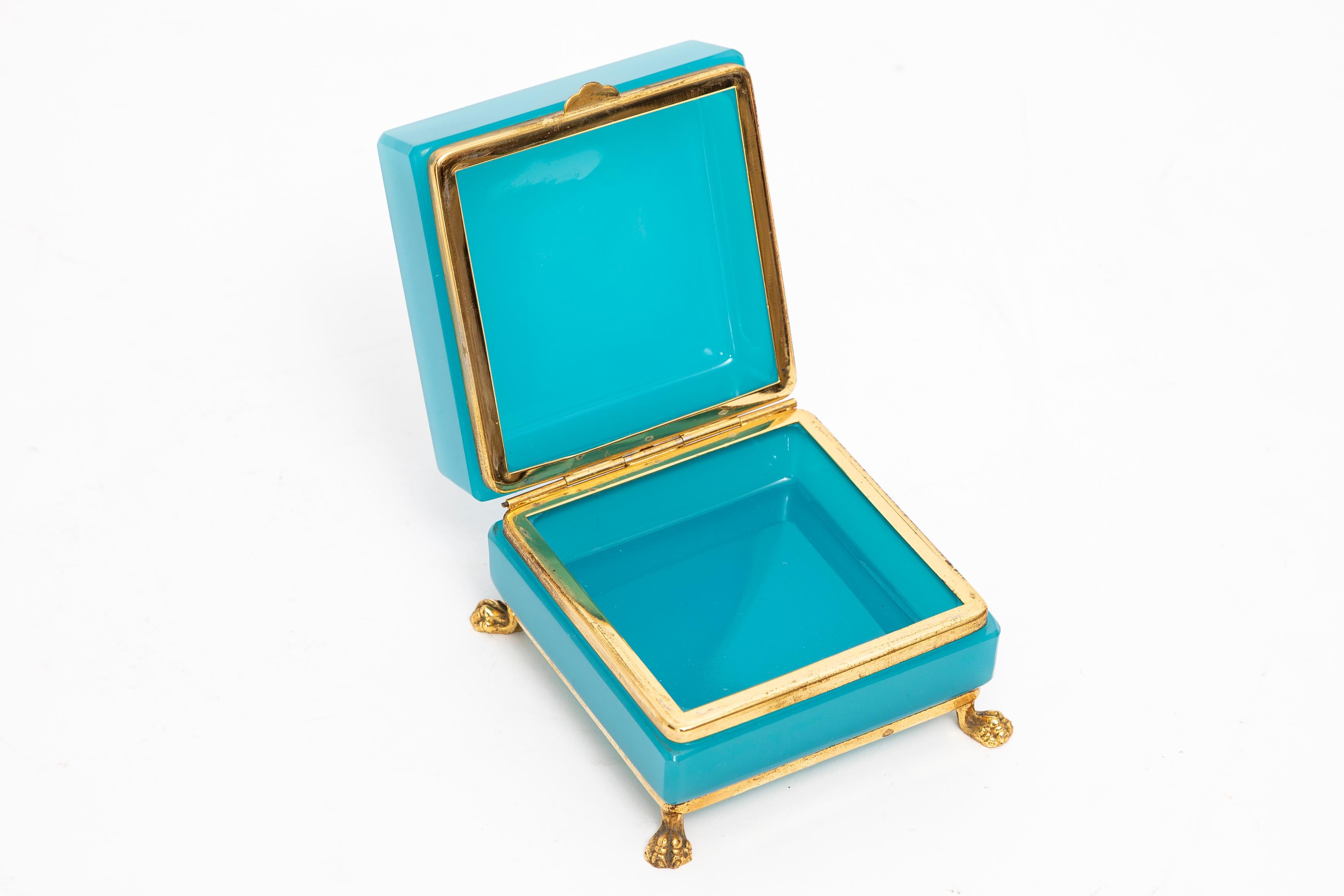 French Mid-Century Mod. Blue Opaline & Dore Bronze Footed Jewel-Box or Tea-Caddy

Indulge in the timeless allure of a truly remarkable artifact with this Fantastic Large Square French Mid-Century Modern Blue Opaline & Dore Bronze Footed