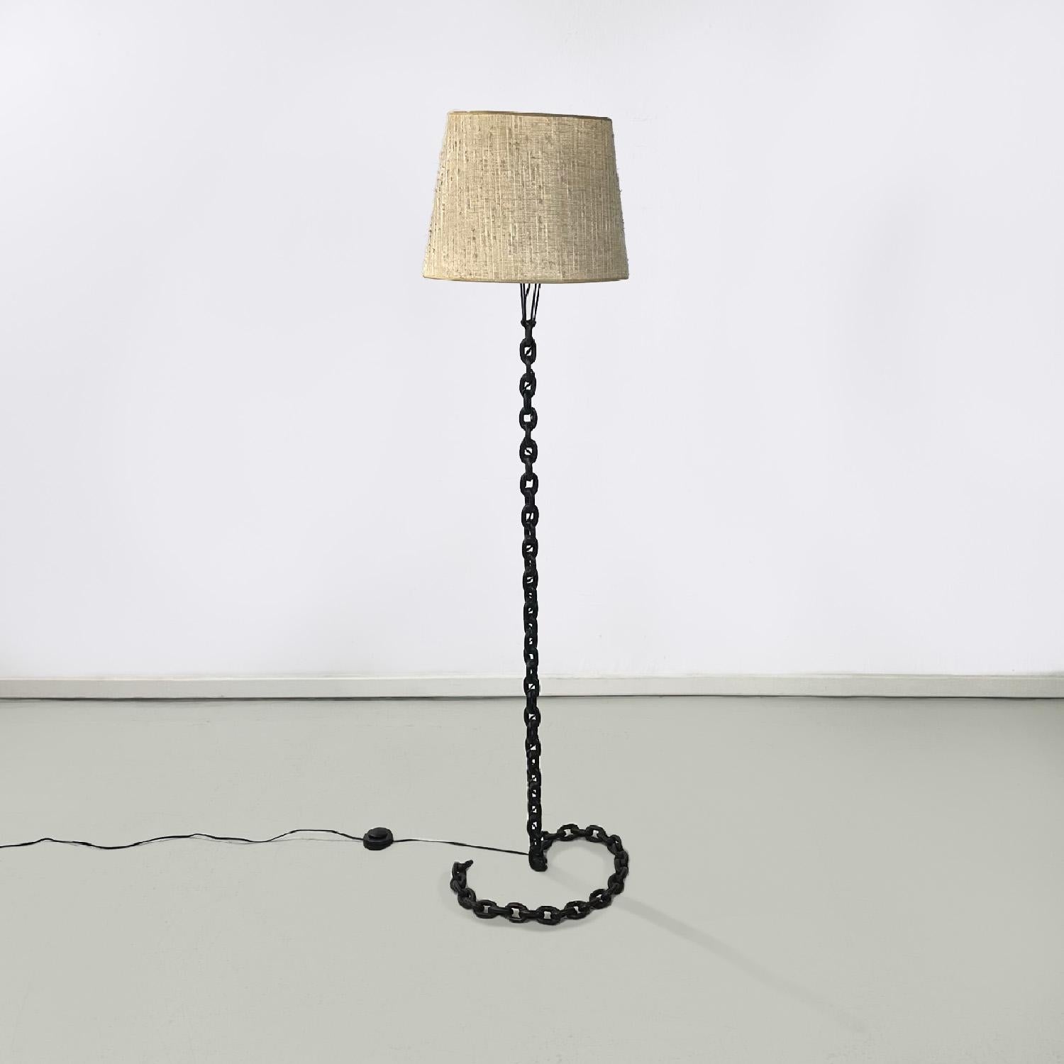 French mid-century modern black metal and beige fabric chain floor lamp, 1950s
Floor lamp with stem and base in black painted metal in the shape of a chain. The stem bends down to create the base. The lampshade is in beige and white fabric. The