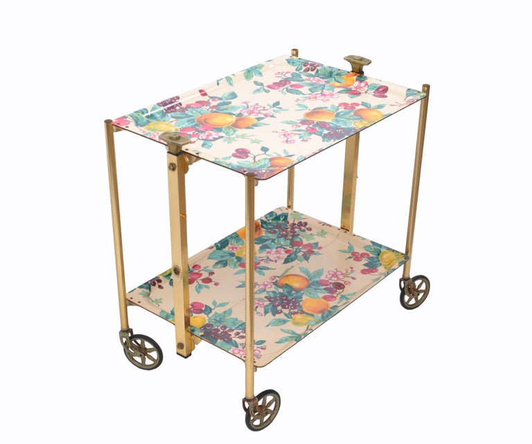Colorful Mid-Century Modern brass and laminate trays serving cart, trolley from the 1950s made by Textable, France.
With 2 pushdown buttons it folds down easily for storage, very practical.
Wheels have a distressed look due to age and use, but run