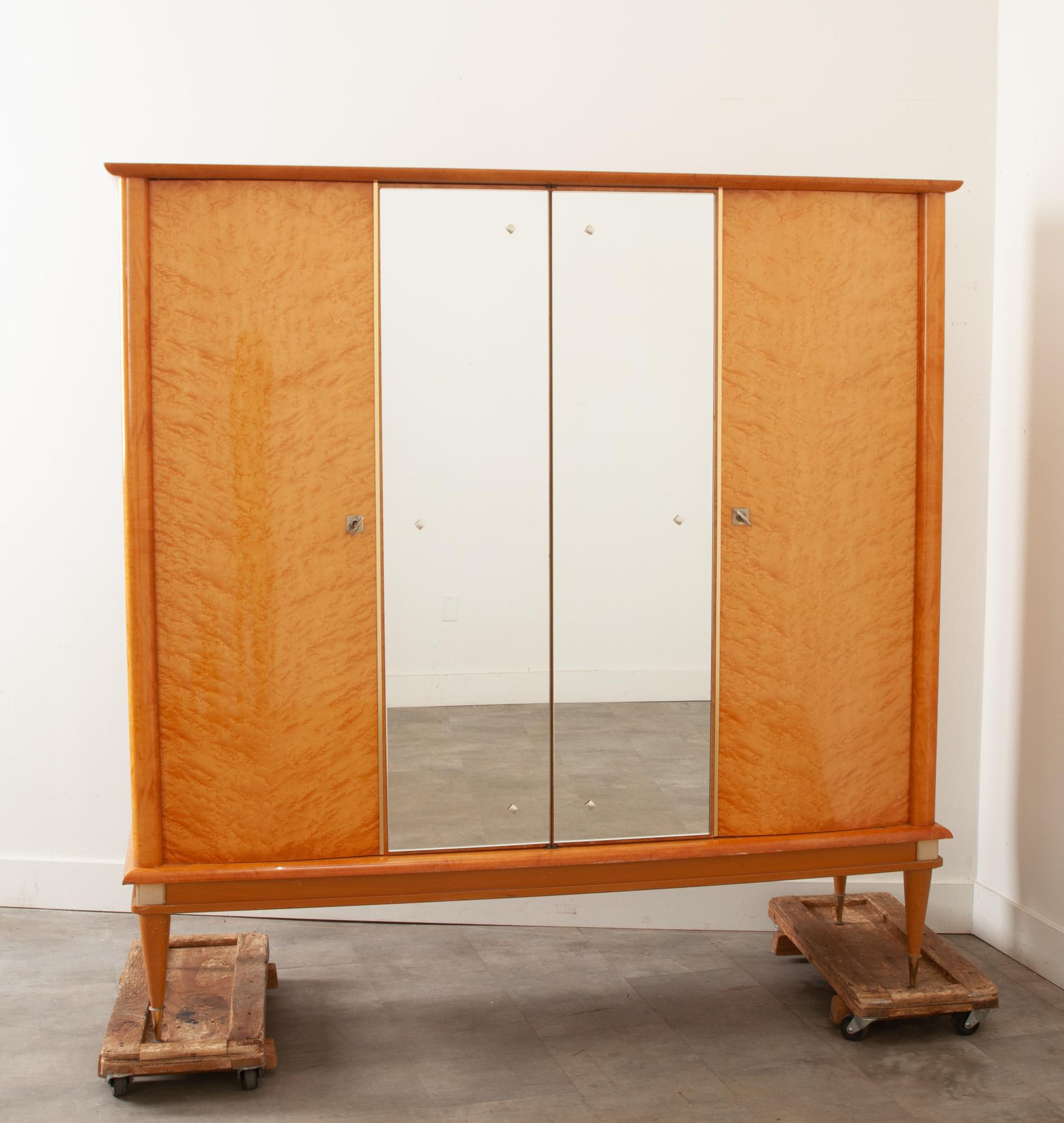 A large dressing armoire produced by Ameublement N.F. “Meubles” in France in the 1950’s /1960’s (label found inside the right door) This sleek mid century modern cabinet would work well in a bedroom or serve as a bar. The exterior of the cabinet is