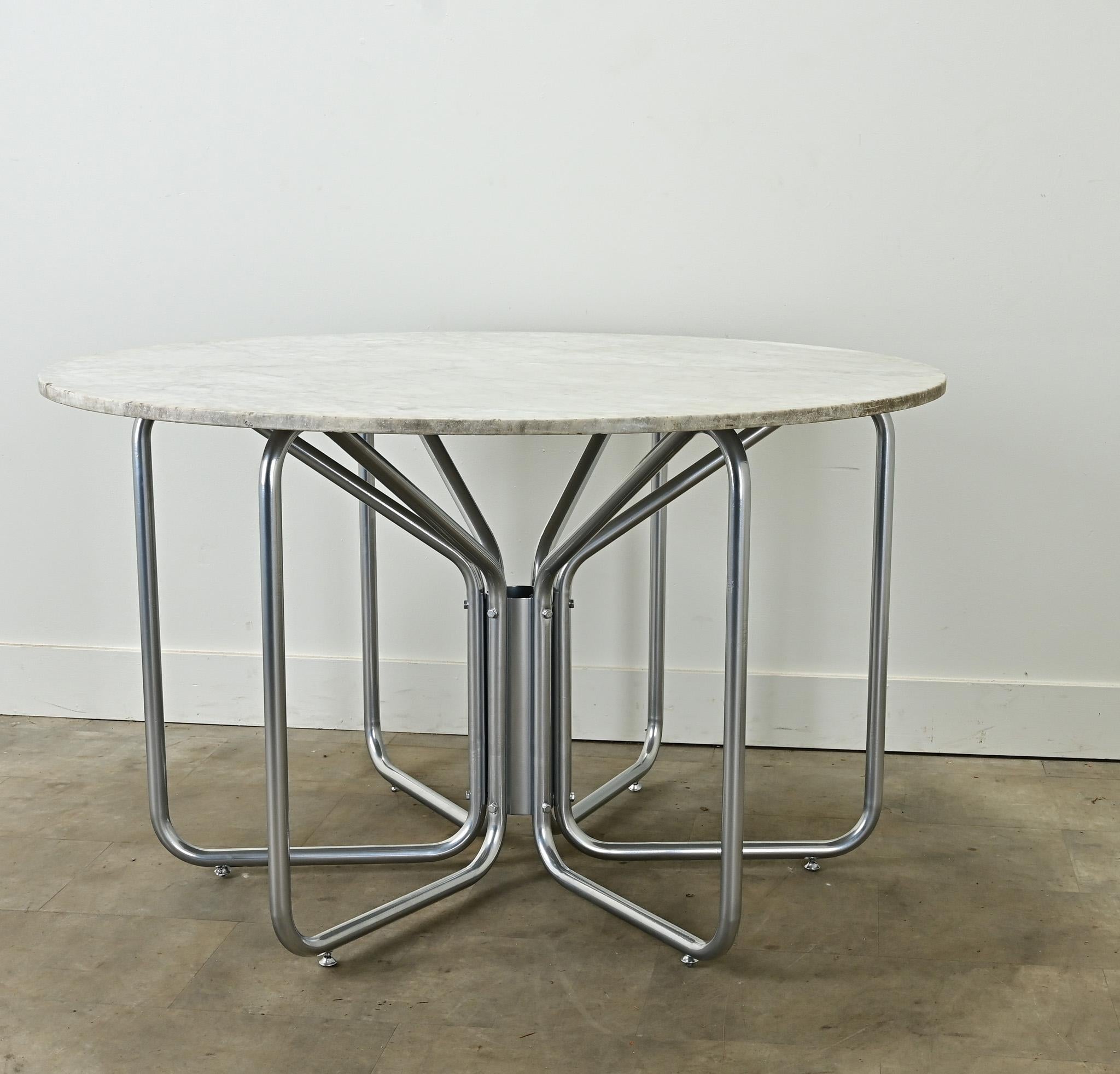 Cette table centrale moderne du milieu du siècle, originaire de France, ne manquera pas de faire sensation dans votre intérieur. Le grand plateau rond en marbre blanc est lisse et patiné. La base tubulaire en métal a été nettoyée et recouverte d'un