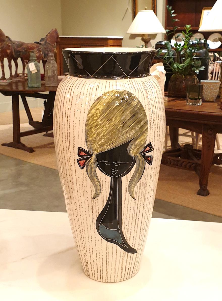 Einzelne Keramikvase aus der Jahrhundertmitte, Frankreich, ca. 1950er Jahre.
Die Vintage-Vase ist aus elfenbeinfarbener Keramik, handbemalt von einem französischen Künstler mit einem stilvollen Mädchen-Dekor, nummeriert und