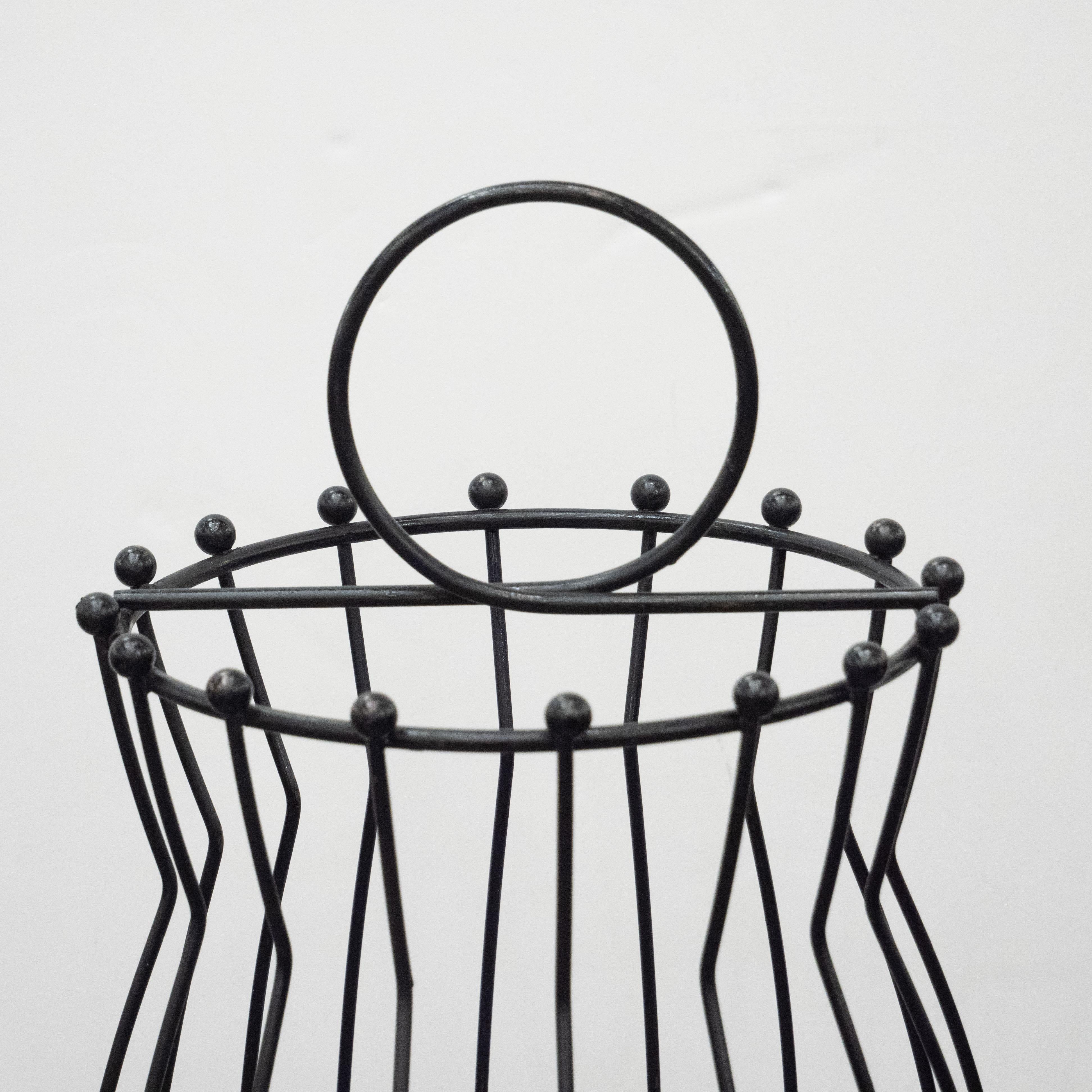 This sophisticated umbrella holder was realized in France, circa 1960. It features a circular base with raised sides from which bowed cylindrical supports ascend tapering in at the neck before expanding outwards again to the circular top. Each of