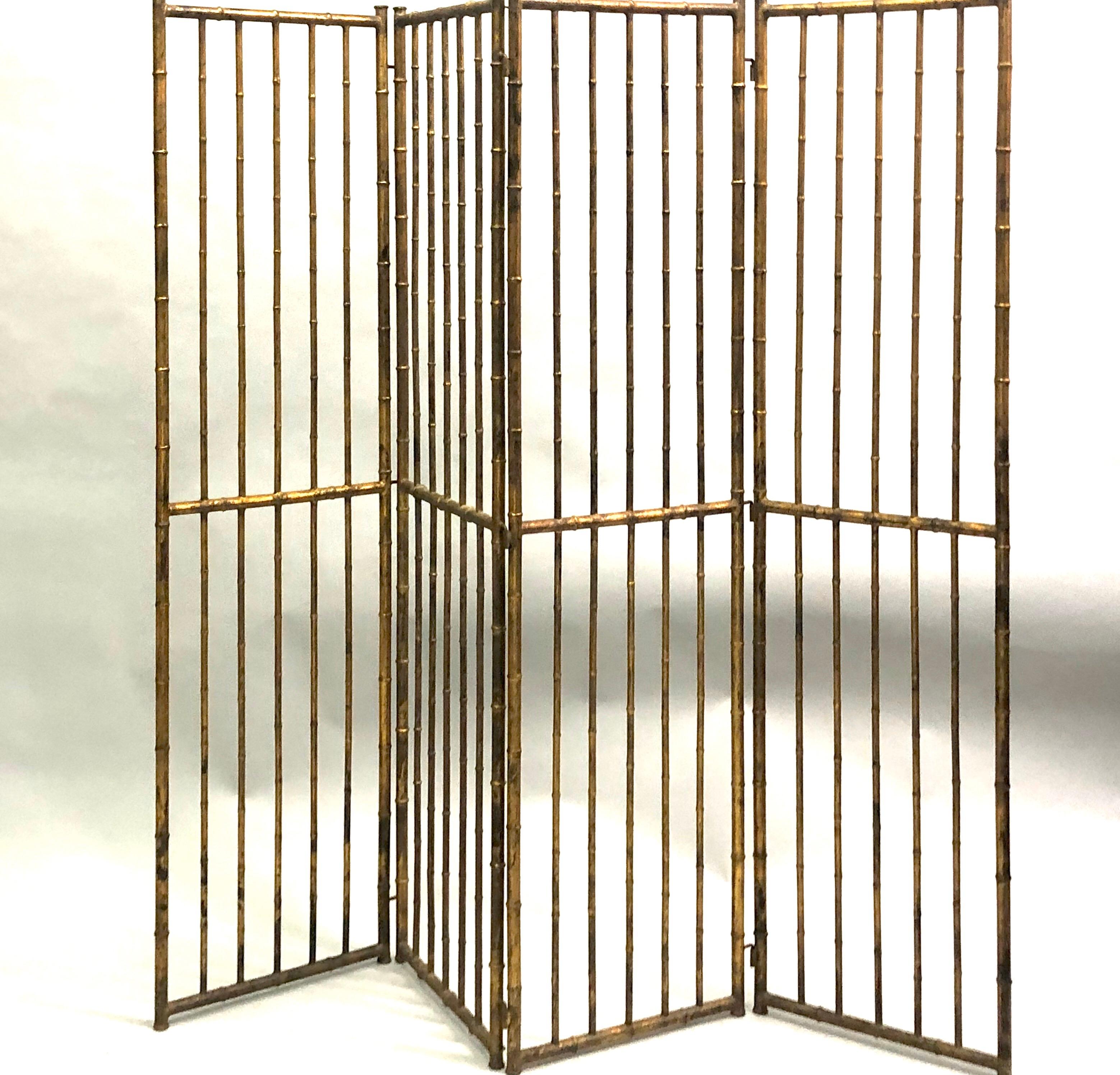French Mid-Century Modern neoclassical screen / room divider in gilt wrought iron faux bamboo by Maison Baguès, circa 1940-1950. The elegant piece is composed of 4 panels with each panel (17.5