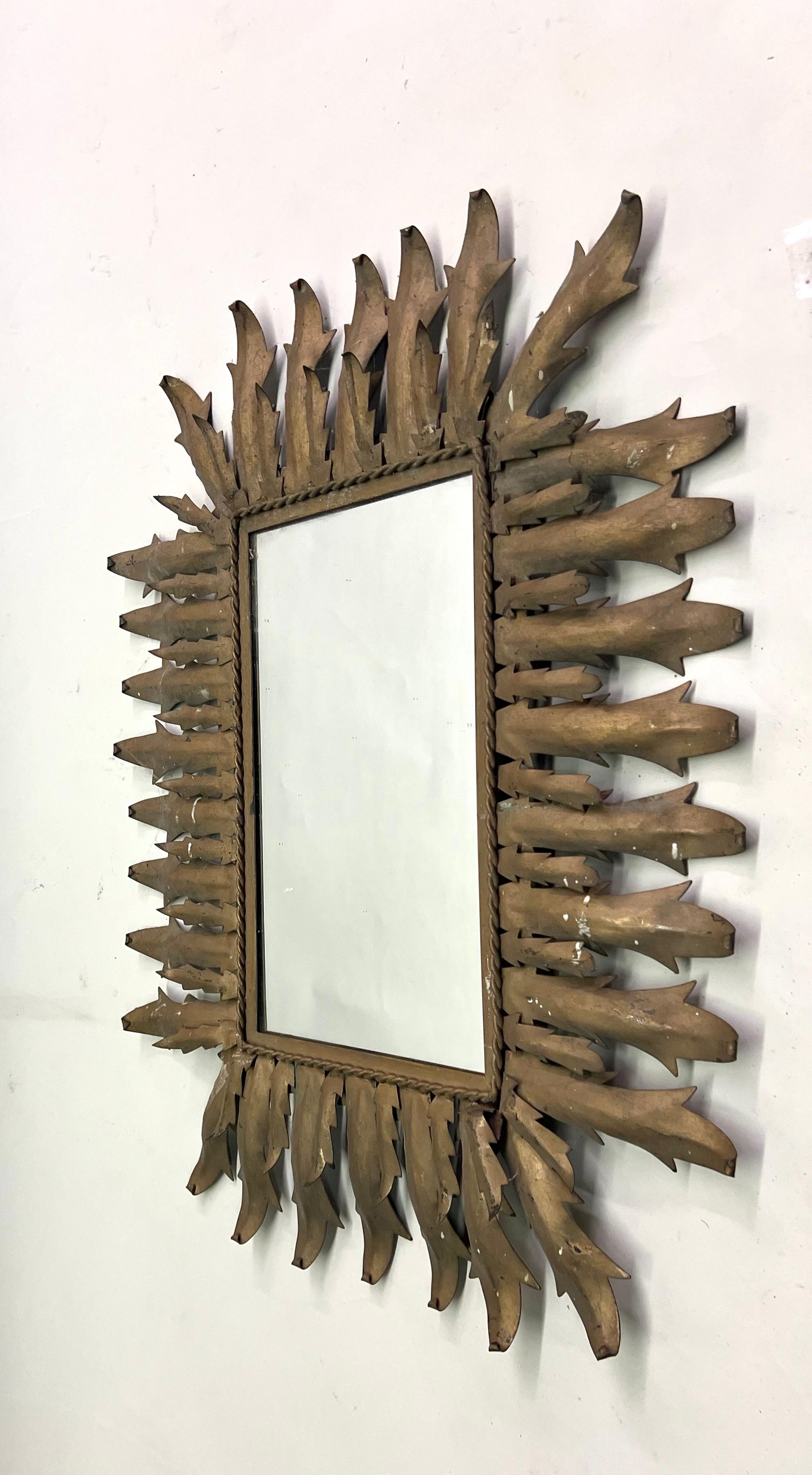 An Iconic French Modern Neoclassical 1940s gilt iron rectangular wall mirror in the form a sunburst in the style of Gilbert Poillerat. Poillerat was the most important iron worker in France during the 1940 period and he worked in close collaboration