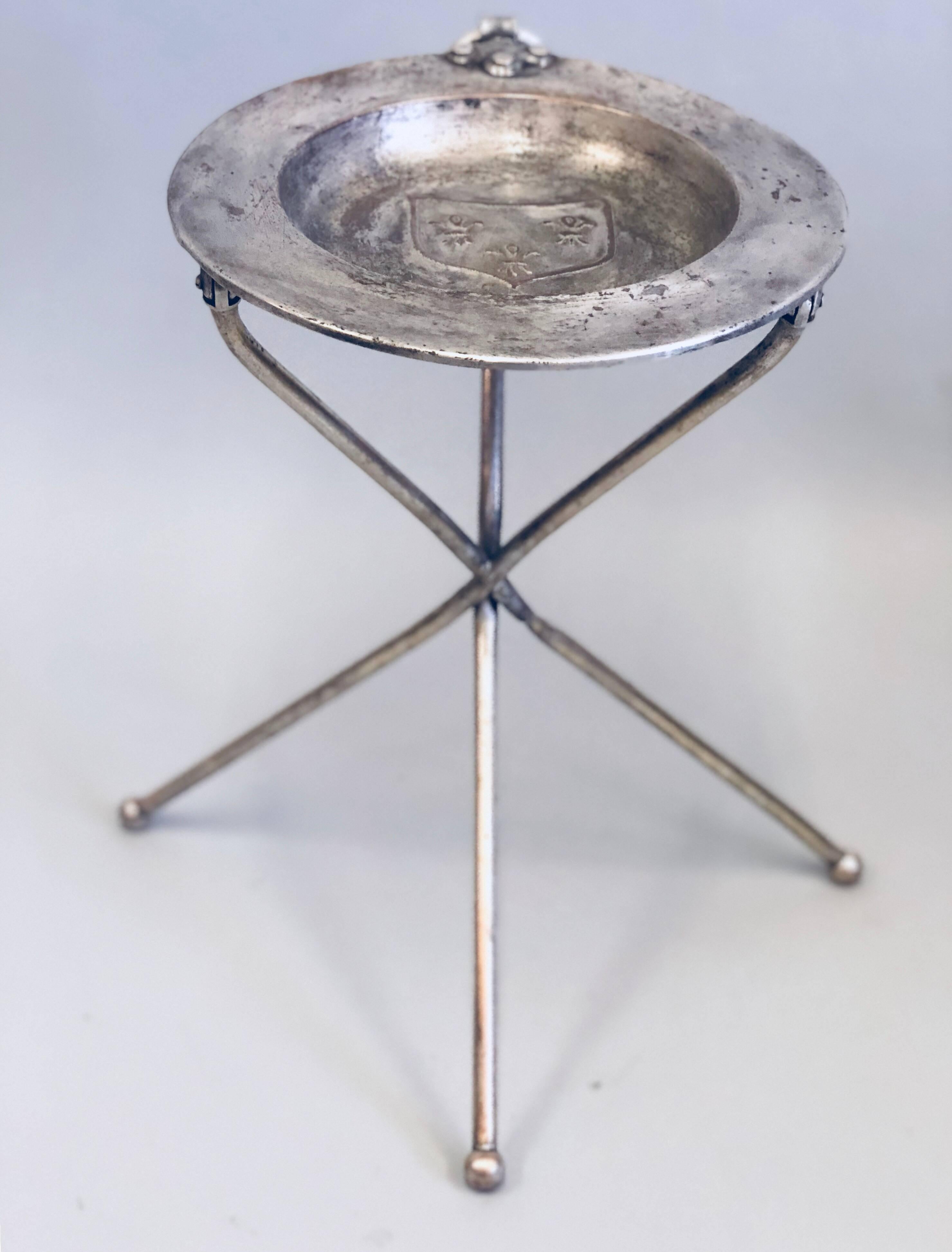 Elegant French modern neoclassical collapse-able tri-leg side table in silvered brass. 

The legs of this table will fold allowing it to be transported easily. The piece is finished with a coat of arms in the centre of the top. The patina is