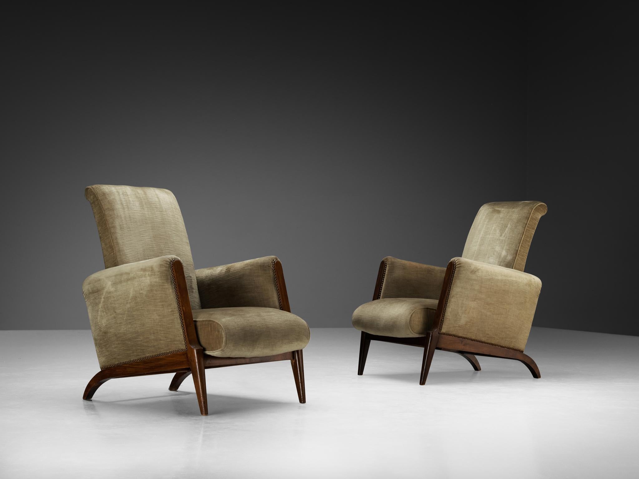 Pair of armchairs, velvet, beech, metal, France, 1950s

These French mid-century easy chairs balance traditional craftsmanship with a pared-down modern silhouette. At first glance, their gently sloped backs and subtly rounded arms suggest a nod to
