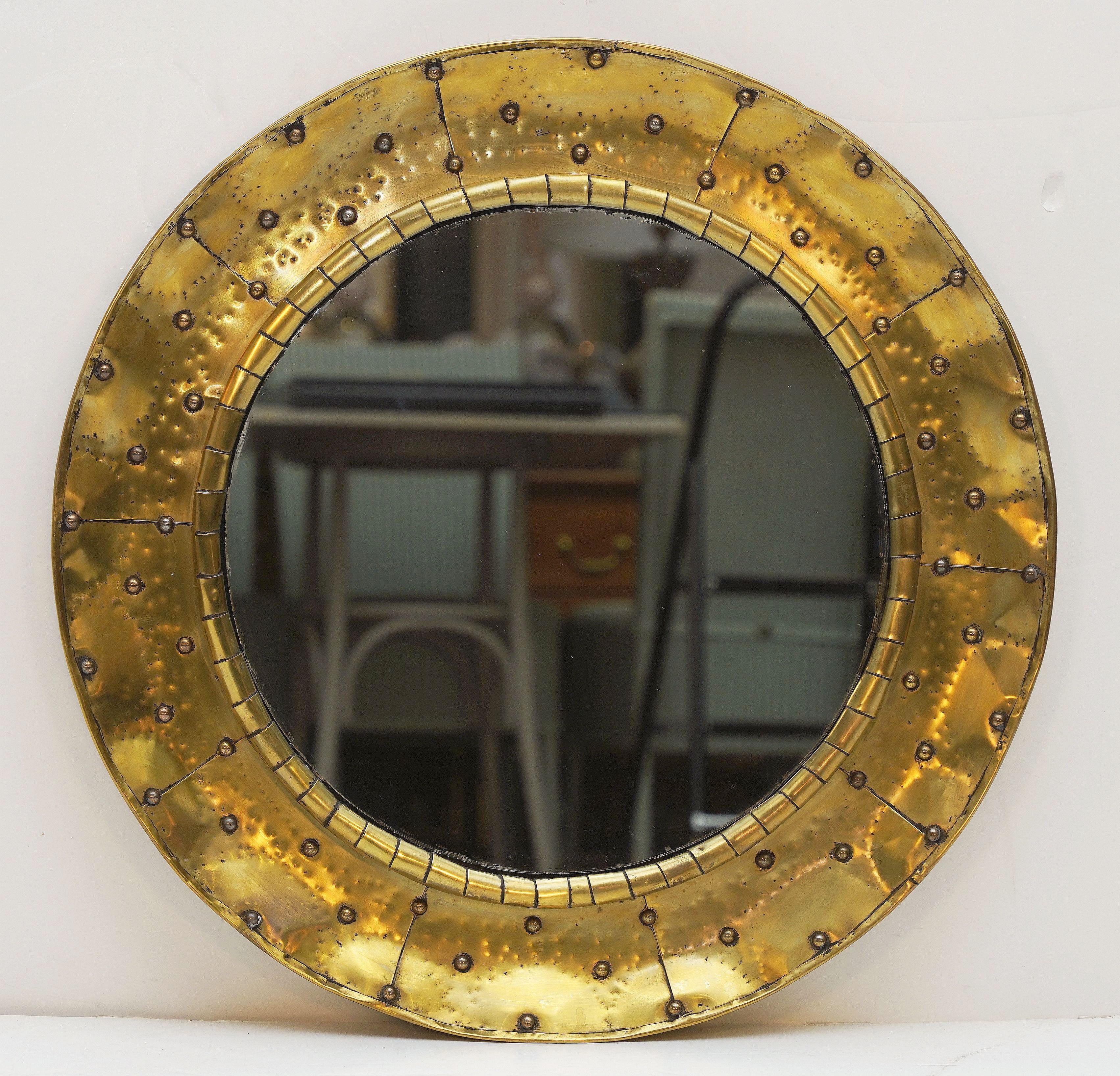 Un raffinato specchio da parete rotondo francese del Mid-Century Modern con una cornice circolare in ottone martellato.

Diametro complessivo: 25,75 pollici
Profondità:  1.88 in
Diametro dello specchio: 17 pollici
