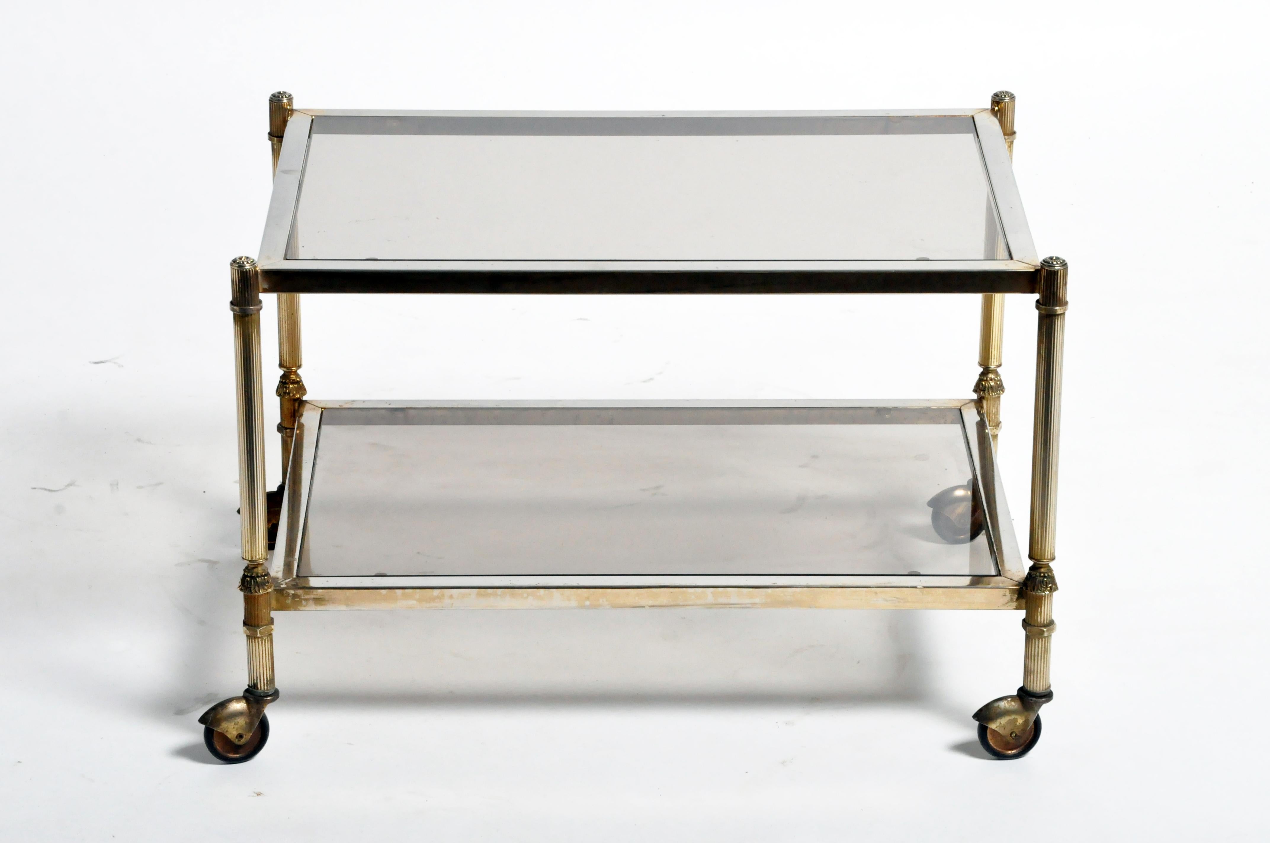 This simple serving table is from France and was made from glass and chrome, circa 1960s. The piece features beautiful clean lines, wheels, and its original patina. Wear consistent with age and use.