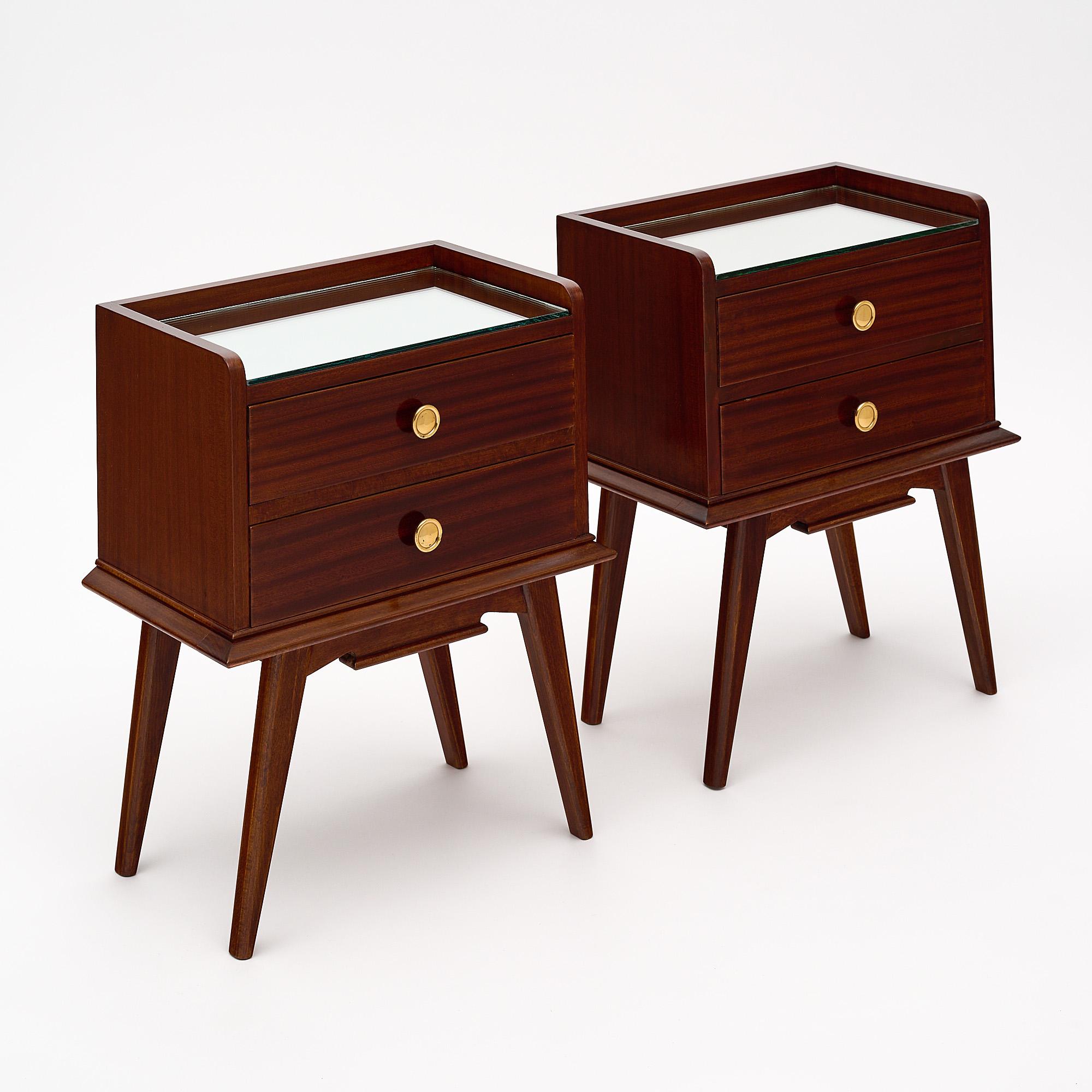 Pair of French side tables made of rosewood, in the manner of Jean Prouvé. Each table features four flaring tapered legs two dovetailed drawers and mirrored tops.