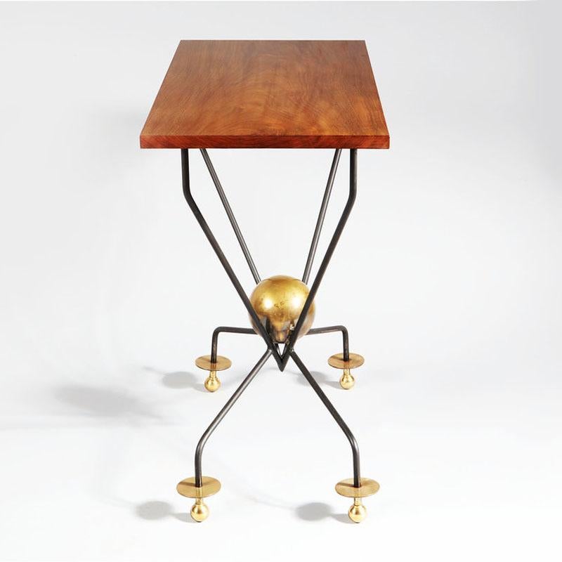 A French mid-century console or centre table, the rectangular mahogany top is supported on a black metal frame with a brass ball at the centre and unusual brass feet.

France, circa 1955.

Height 28 inches, width 40 inches, depth 20 inches.