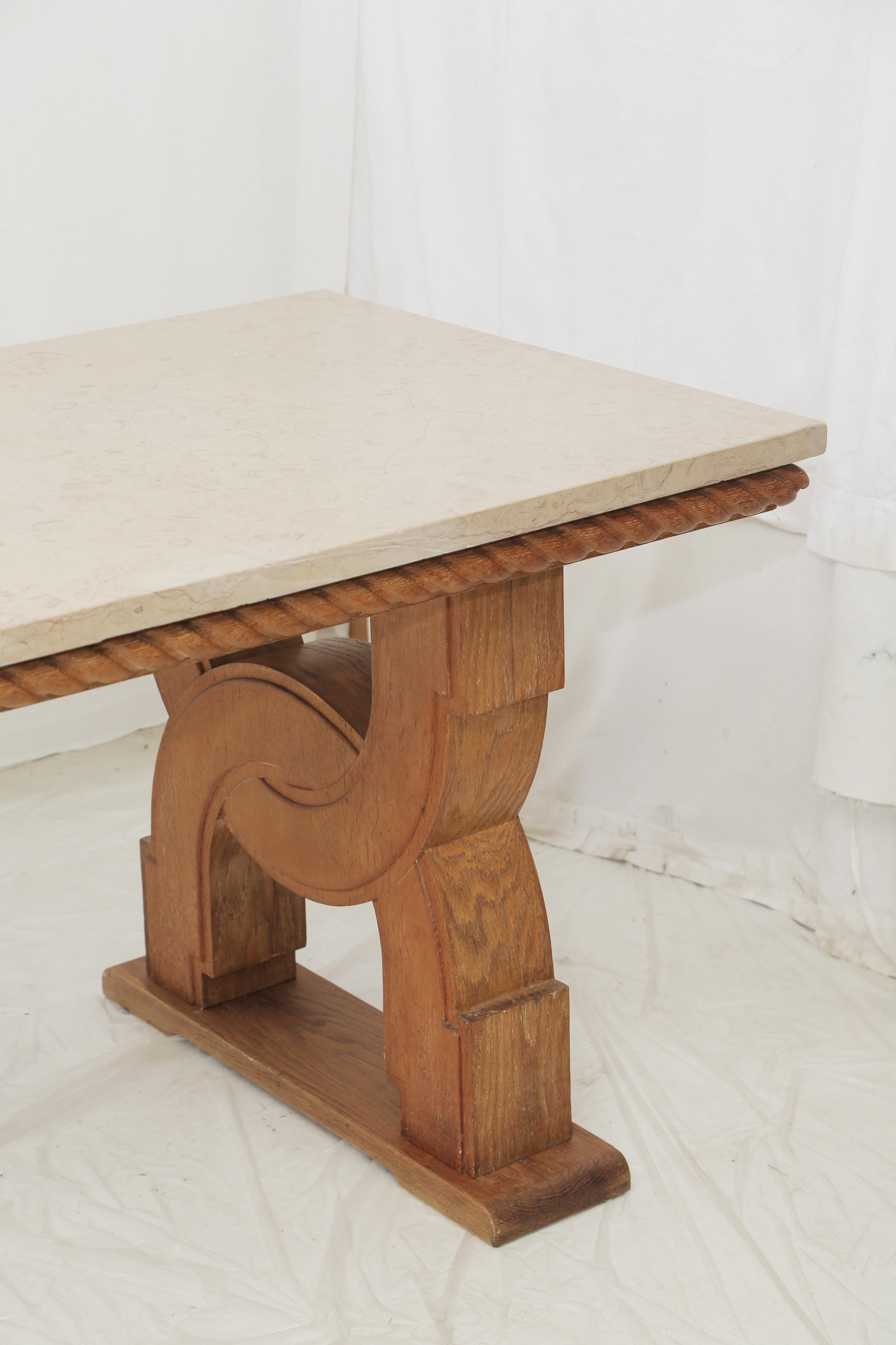 Hand carved oak base in the style of French designer Jean-Charles Moreux with a carved rope all around the upper part and underneath. Beige Comblanchien stone top. A rigorous and very architectural design piece which could fit as a console table or