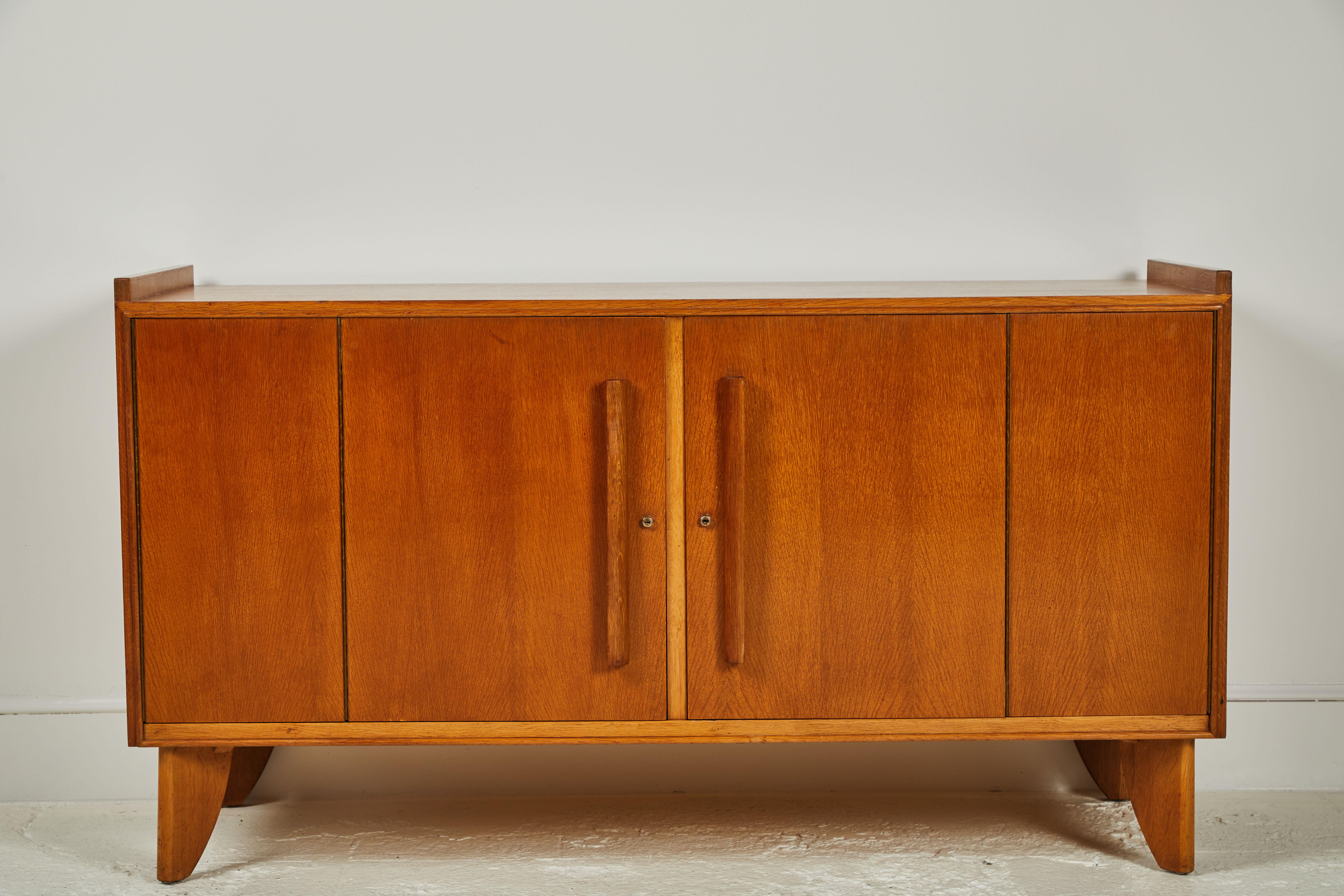 French midcentury oak credenza with beautifully bi folding doors. Inside details offer wooden pullout / pull-out drawers.