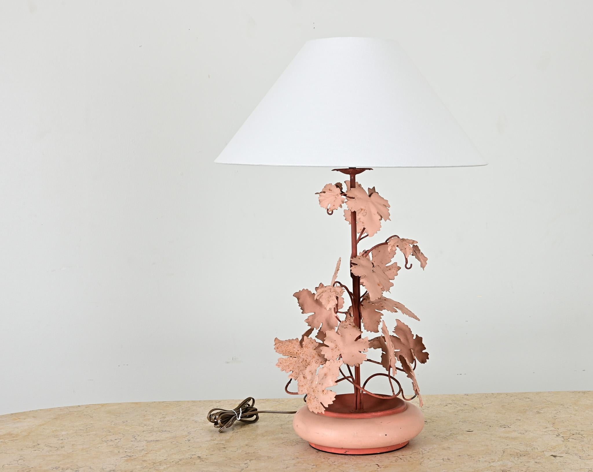 A playful mid century table lamp is the perfect whimsical addition to any interior. The metal lamp has a rounded saucer base with a center cylinder wrapped with vines and leaves. Recently wired for US electrical using UL listed parts with a new