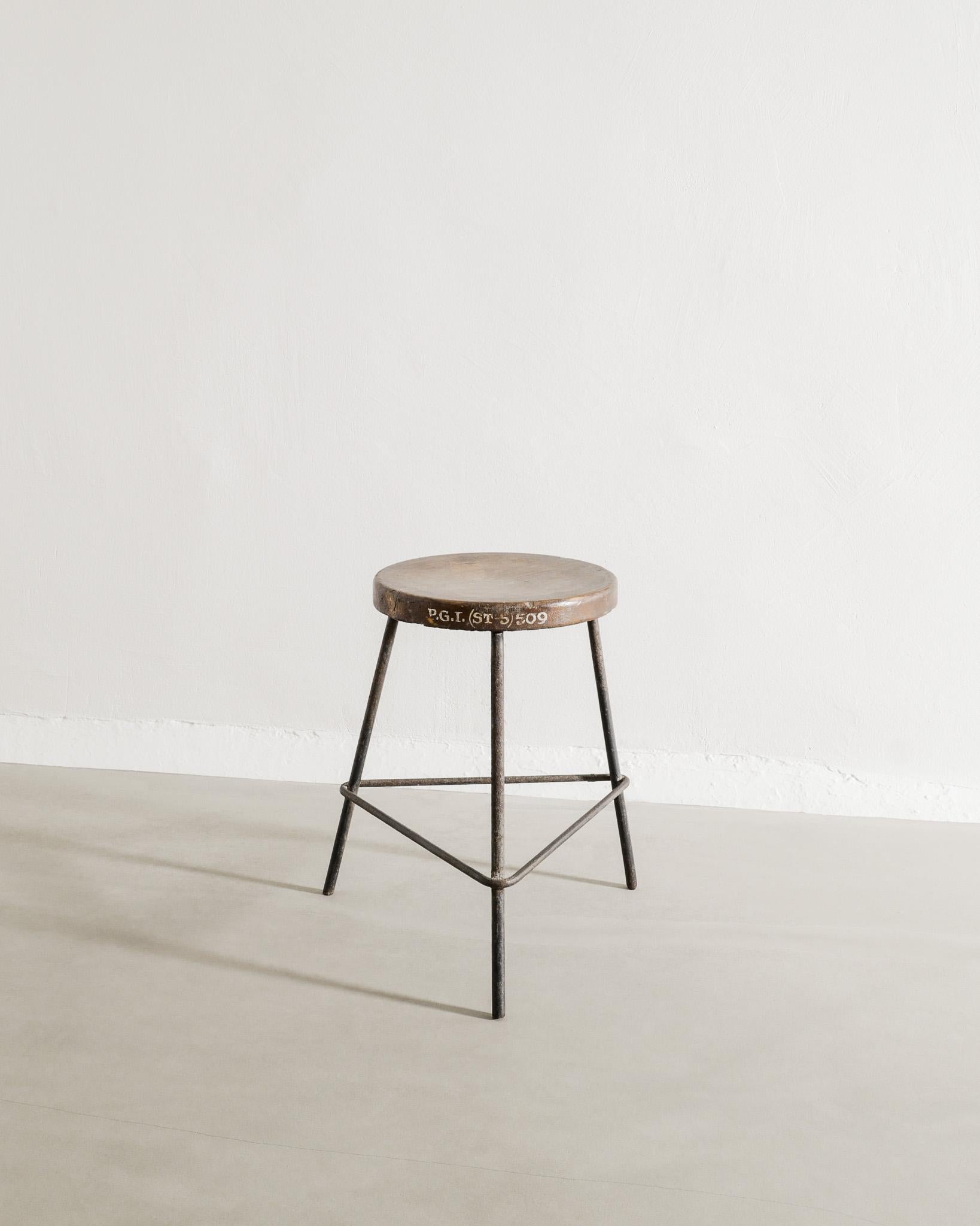 Raro e decorativo sgabello basso da bar francese di metà secolo in legno di teak tinto marrone scuro e ferro patinato di Pierre Jeanneret prodotto per Chandigarh, India, anni '50. In buone condizioni originali, con una bella e iconica scritta sul