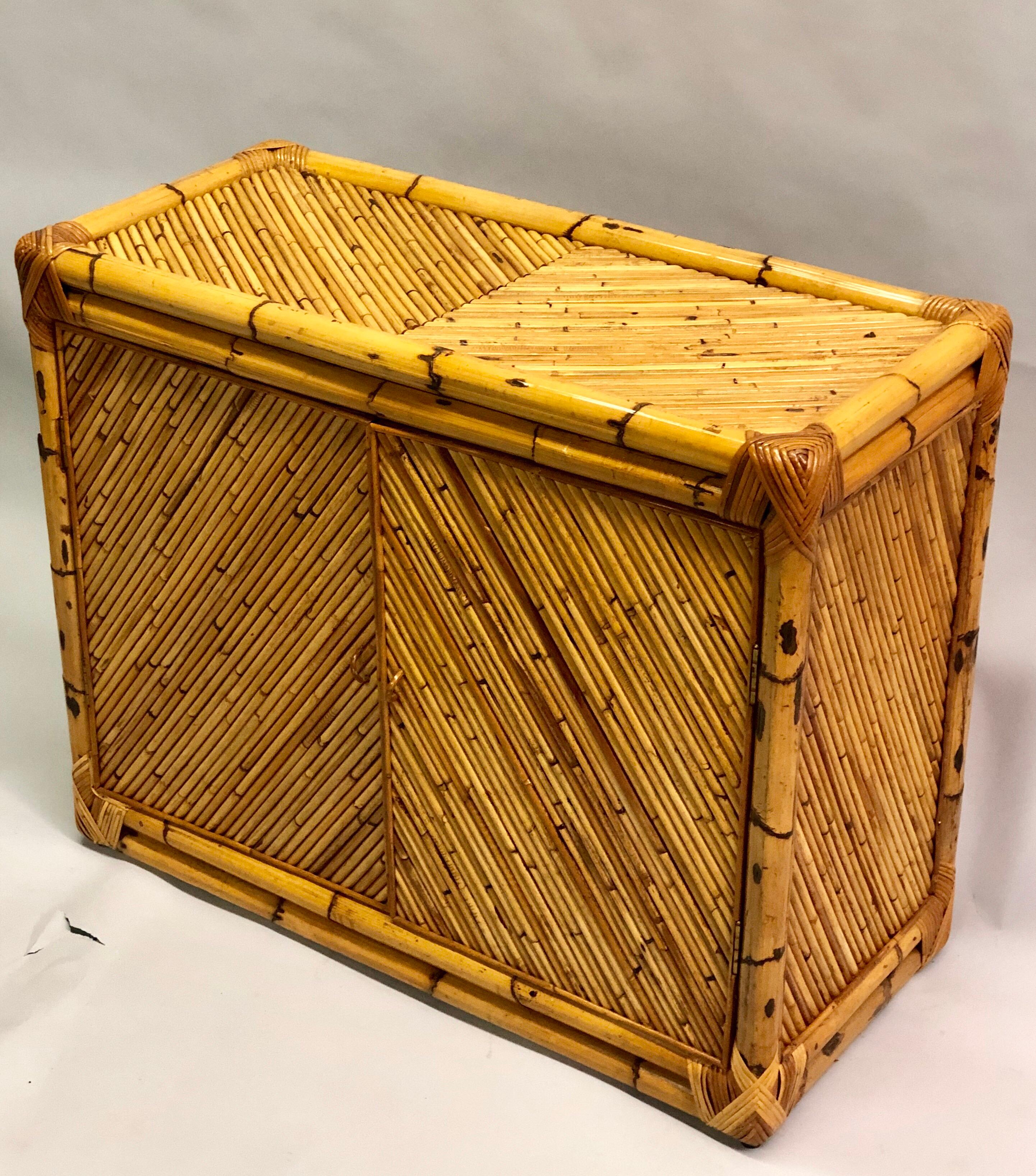 Elegant French Mid-Century Modern neoclassical influenced rattan and bamboo sideboard, buffet, commode or cabinet.

The rattan is cross-angled in a sober neoclassical chevron pattern on the top and doors. The sides are also cross-angled. 

Can