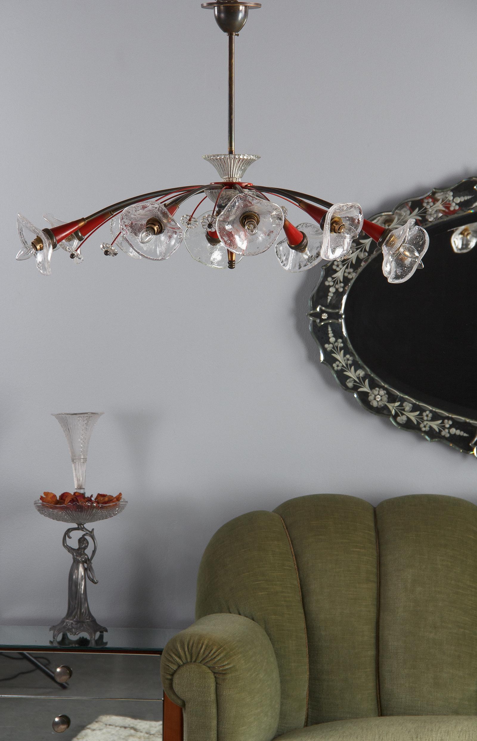 A fabulous vintage metal and glass chandelier by Lunel, midcentury French. A spray of ten black arms shoot out from the centre in an oval shape, each with a painted red bulb mount holding a blown glass bulb cover and a small candelabra bulb. The