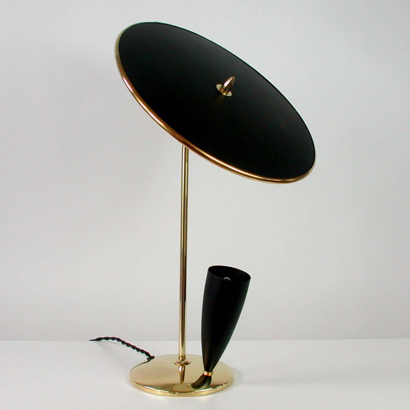 This elegant Maison Arlus style table light was designed and manufactured in France in the 1950s.

It has got a black adjustable reflecting lampshade, a brass lamp arm and black bulb holder.
The lamp is in excellent vintage condition and has been