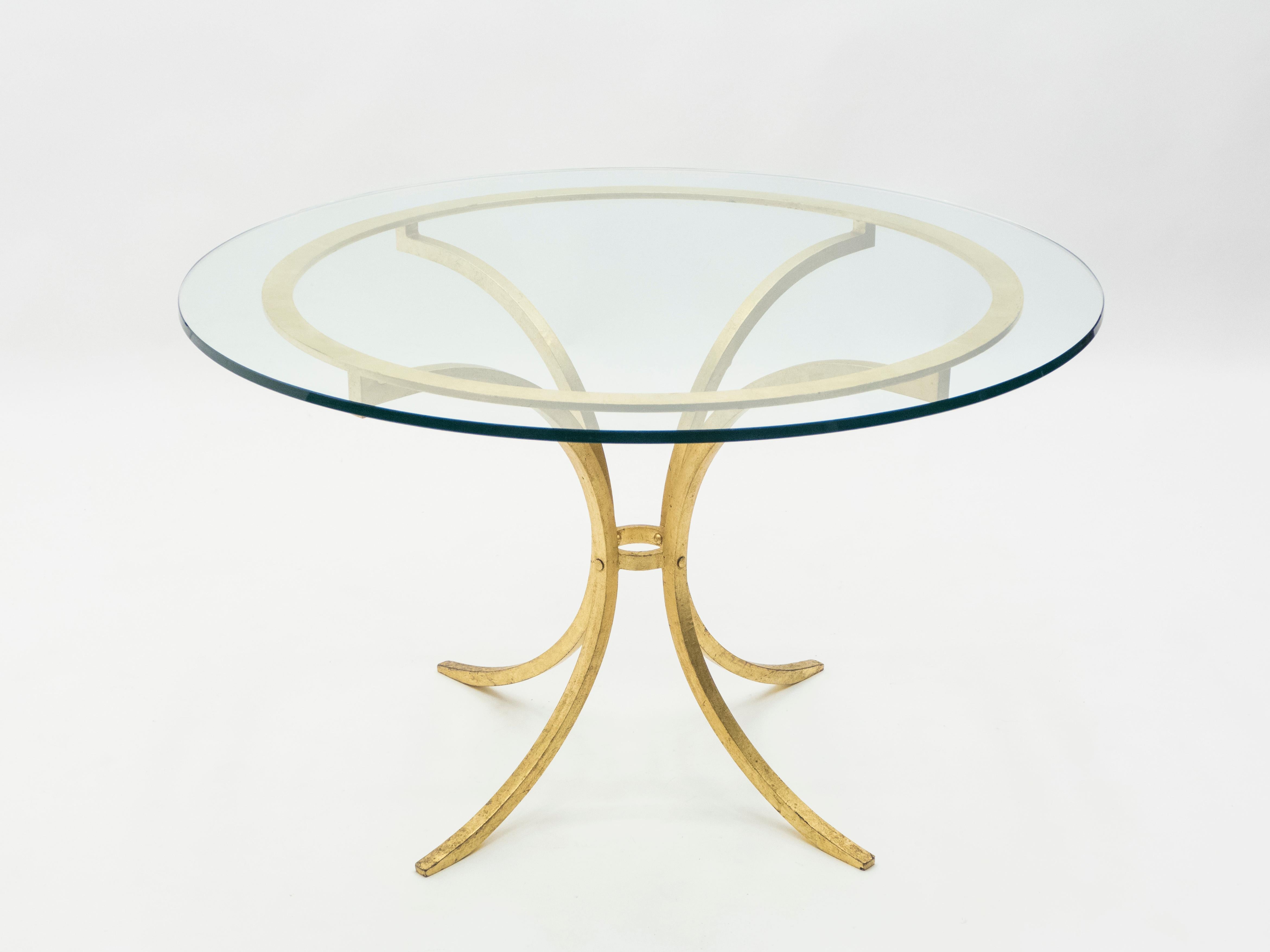 A strategically sparse design with high quality materials gives this dining table a sturdy yet delicate appeal. Wrought iron has been gilded with gold leaf for a gentle warm golden patina throughout the entire structure. A thick transparent glass