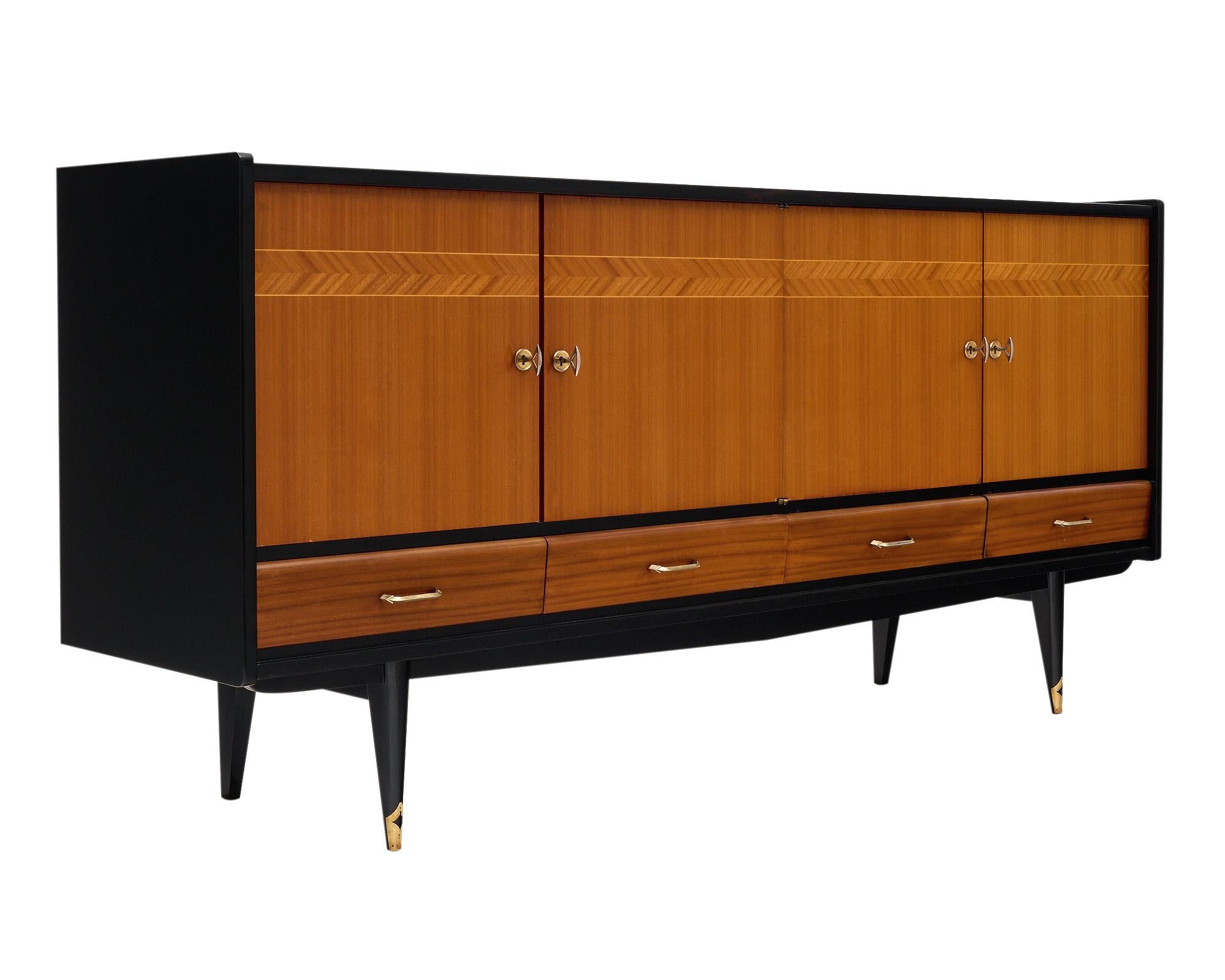 Buffet or enfilade from France with an inlaid rosewood façade and ebonized rosewood body. The piece is supported by four tapered legs, the front two feet are capped in brass. The four doors all have working locks and keys and open to interior
