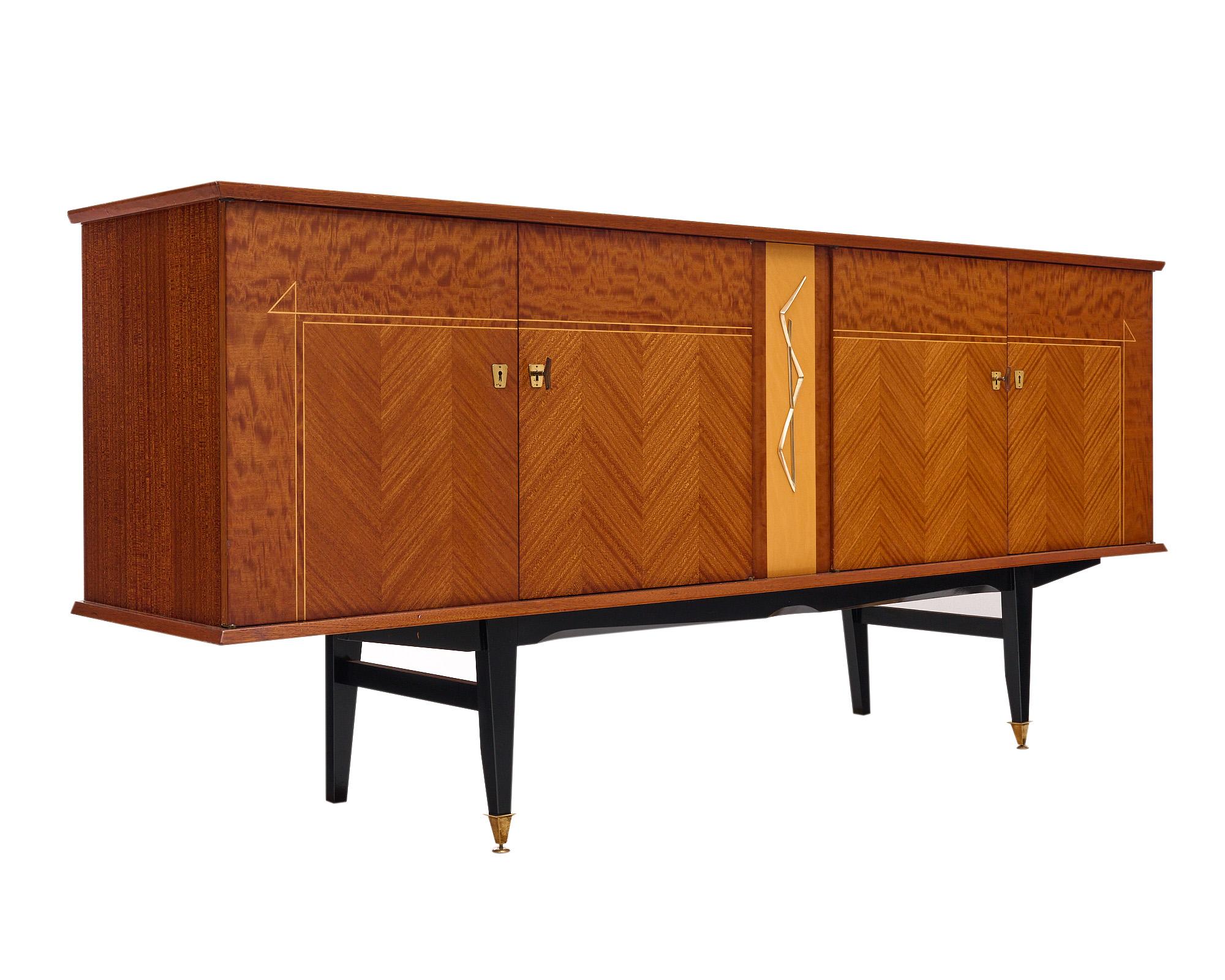 Mid-Century style buffet from France made with an alternating rosewood parquetry and burled rosewood veneer on the façade. The four doors each open to individual interior cabinets with shelves. The brass hardware and décor are all original to the