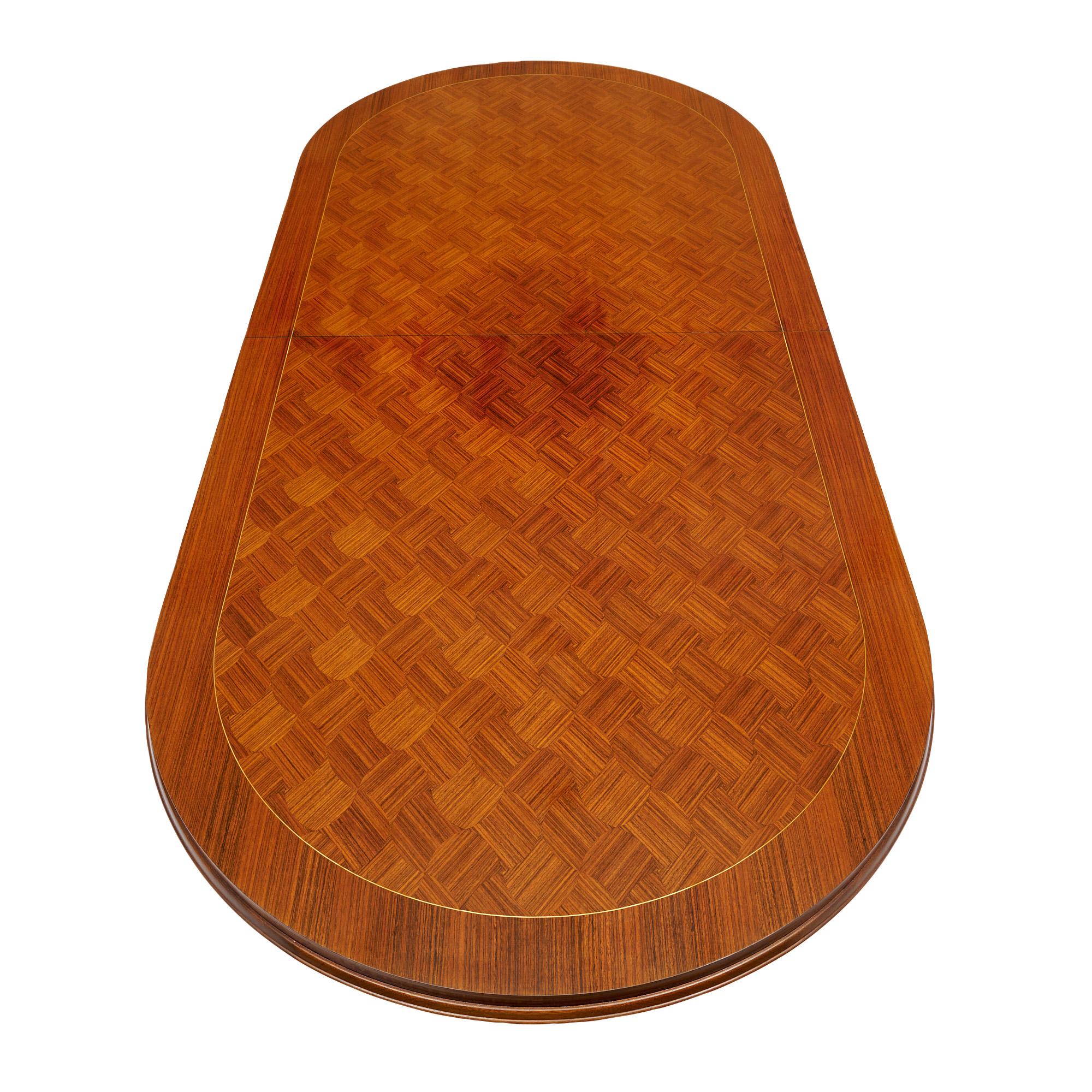 Dining table from mid-century France made of a solid wood construction. The top features a striking Rosewood parquetry design. The four legs are adorned and capped with brass. This piece is in very nice vintage condition with only minor surface wear