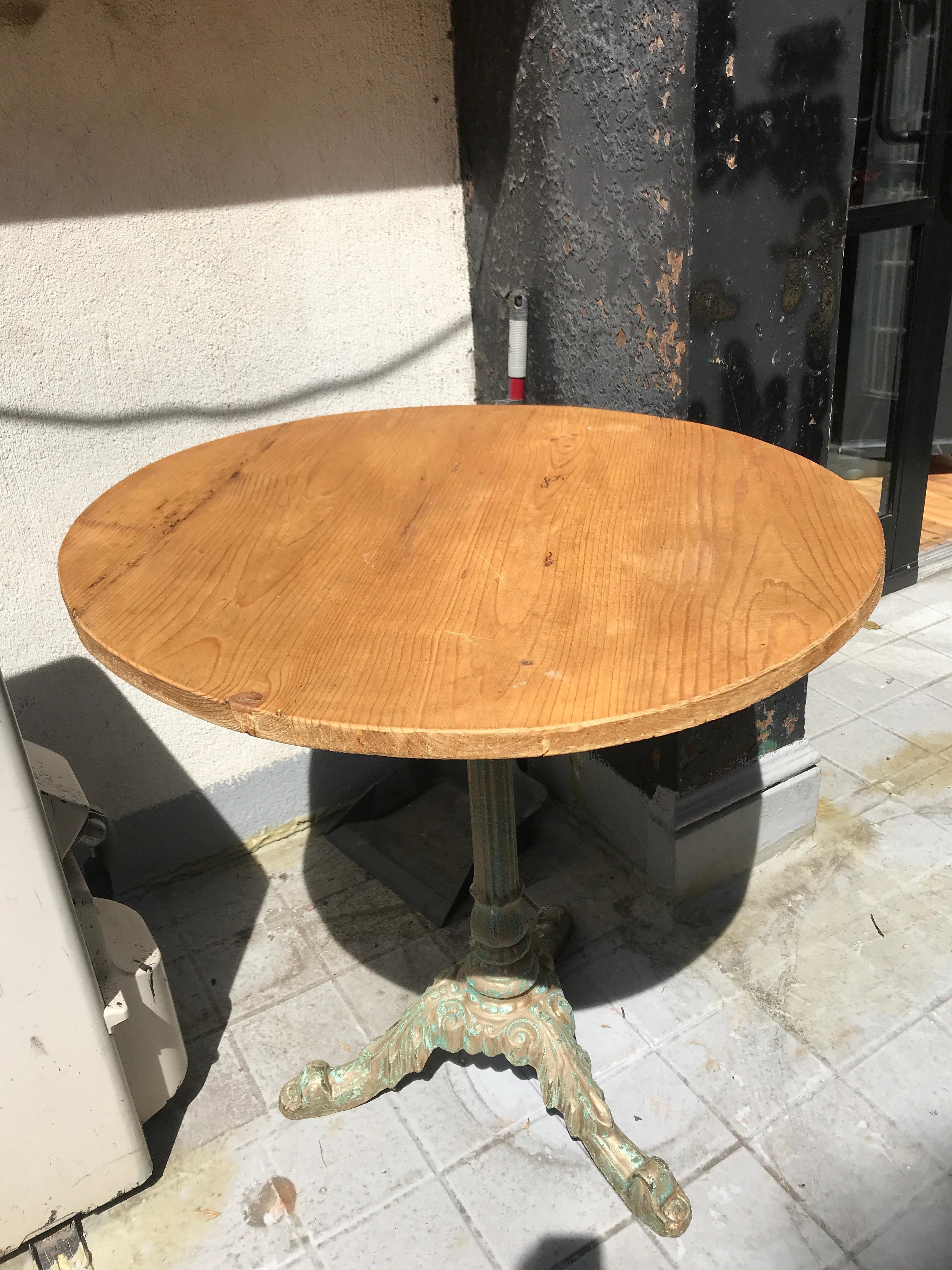 A French mid-20th century patio dining table. This round shaped metal patio table has a wonderfully aged patina and features a round top over a decorative stand. This midcentury table features it's original paint, much of which has been worn with