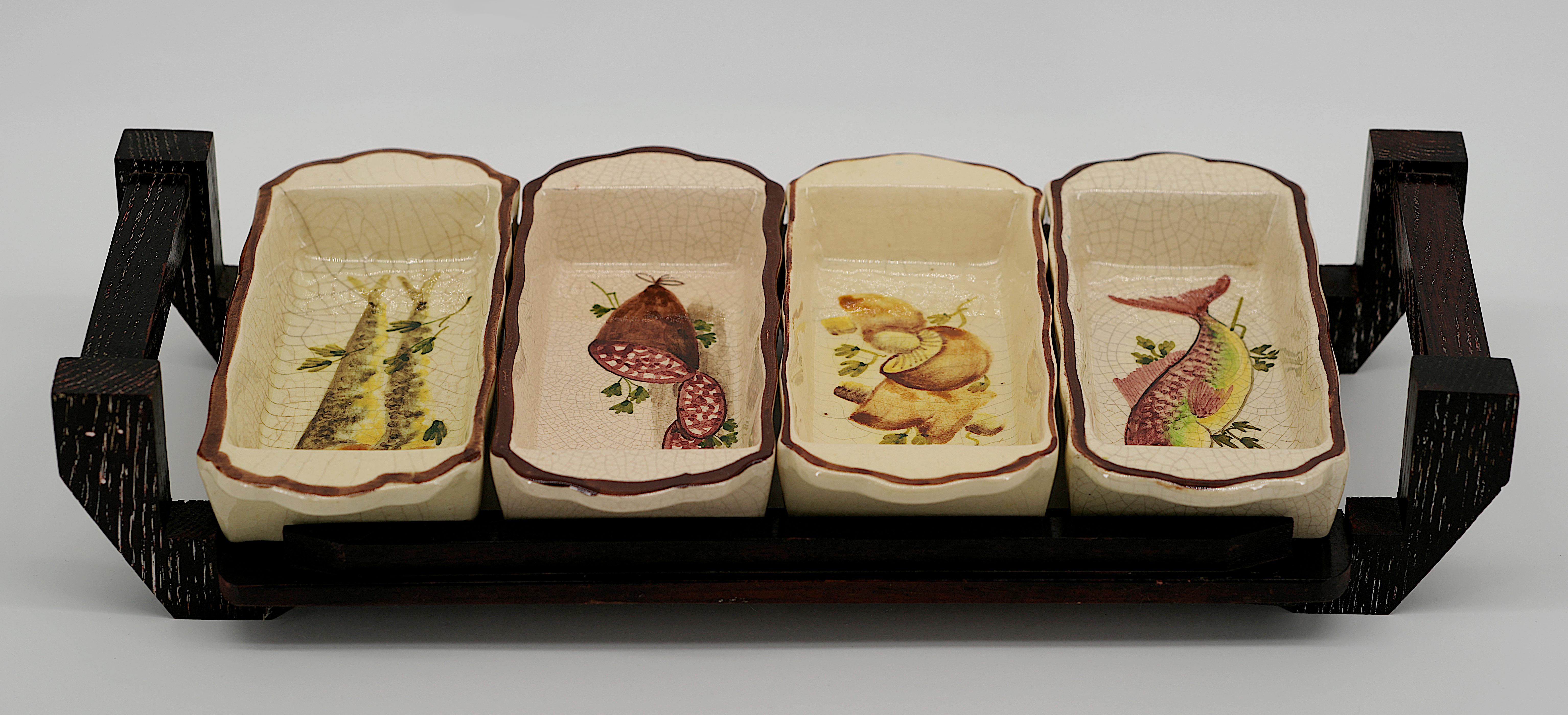 French Mid-century appetizer dishes, Vallauris, 1960s. Set of 4 ceramic dishes and a wooden tray. Each dish shows a different decor. Mushrooms, sardines, fish and sausage. Width : 18.4