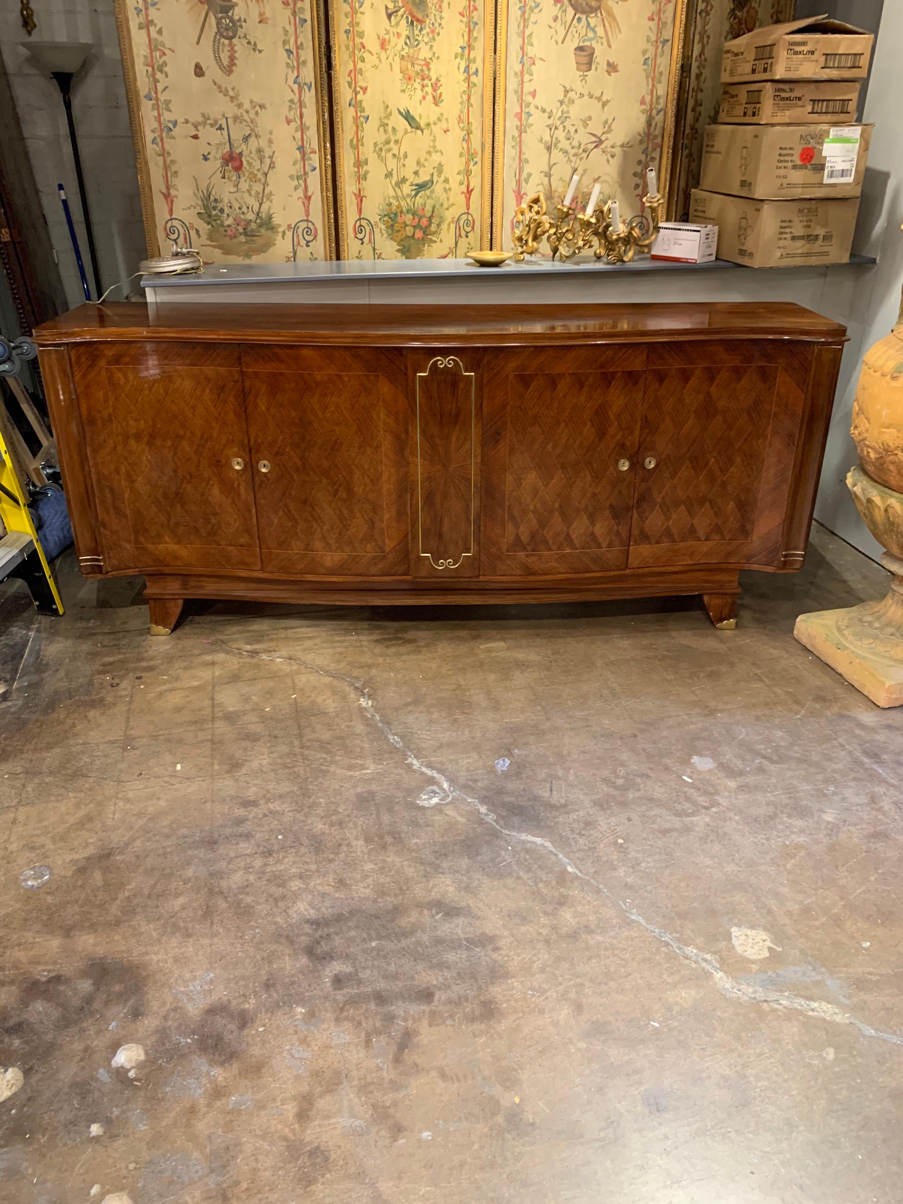Superb French midcentury shaped mahogany sideboard with beautiful parquetry design. Lovely brass hardware as well. Very fine quality with loads of storage and an amazing finish!