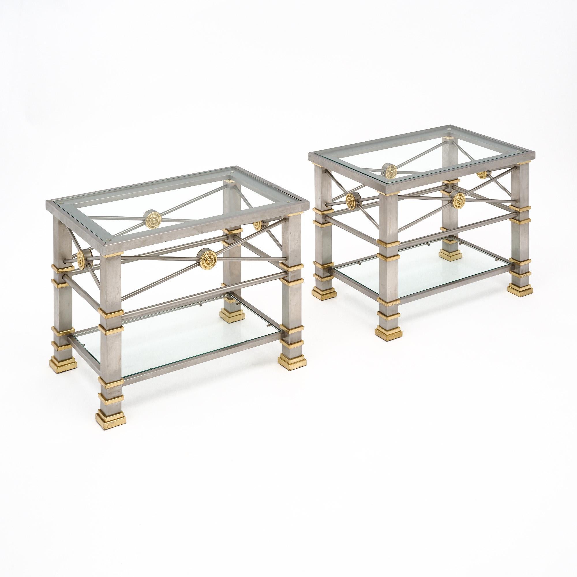 Pair of side tables from France with chrome structures and details in brass. We love the x-shaped stretchers and strong design. Each table has a glass top and a lower glass shelf.