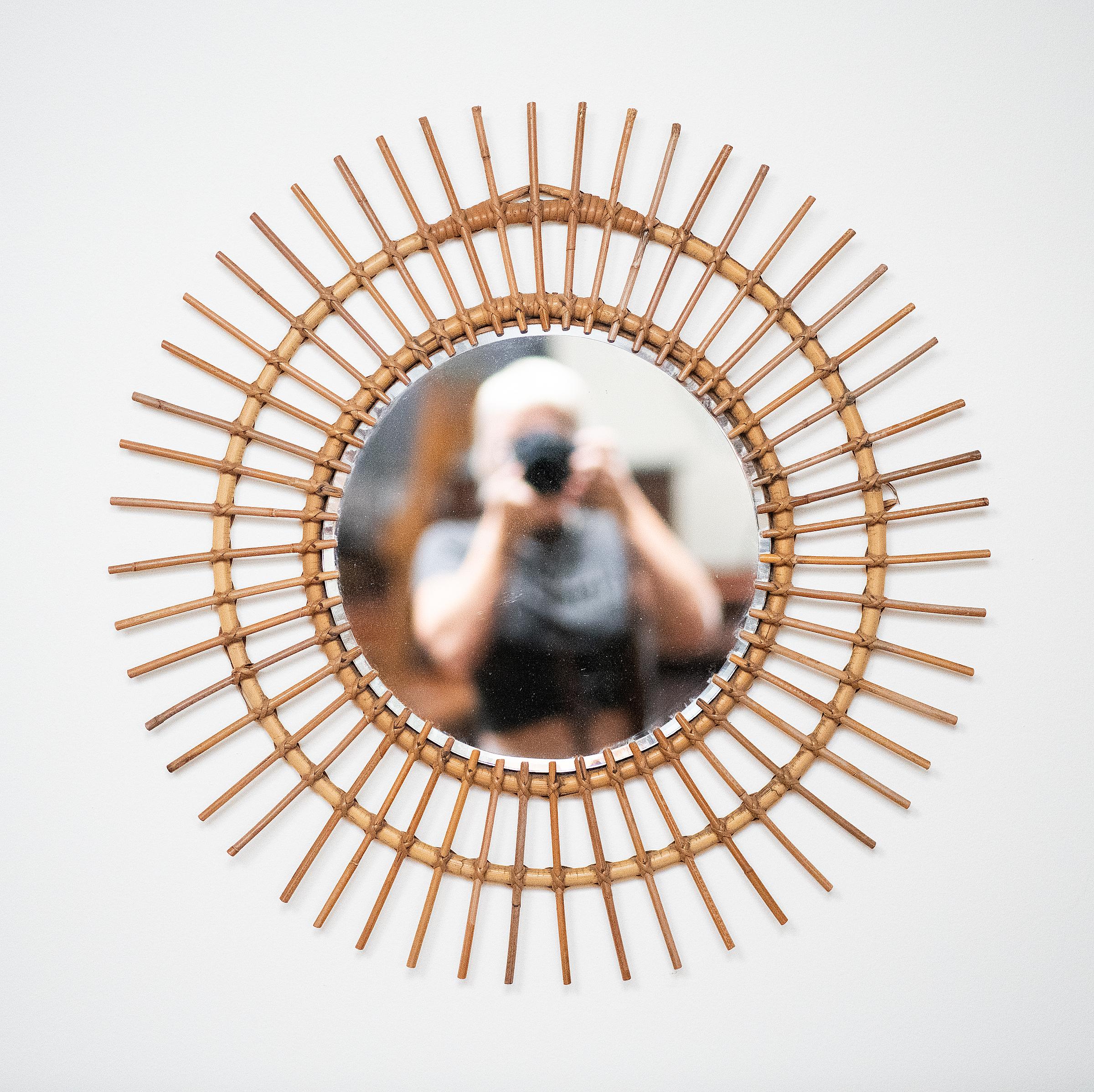 A lovely French sunburst (or starburst) mirror with a beautiful arrangement of bamboo and rattan rays woven and arranged around the mirror plate glass center.  

Diameter 27 3/8 inches