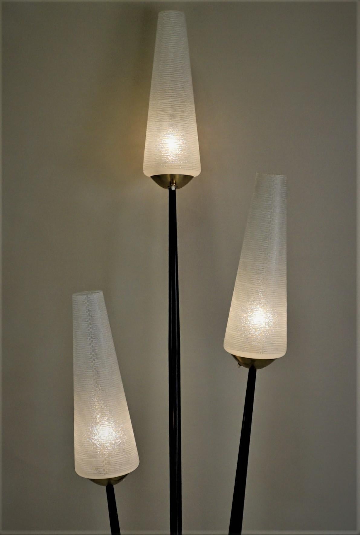 A fabulous midcentury three-light, bronze and black lacquered with textured glass floor lamp.