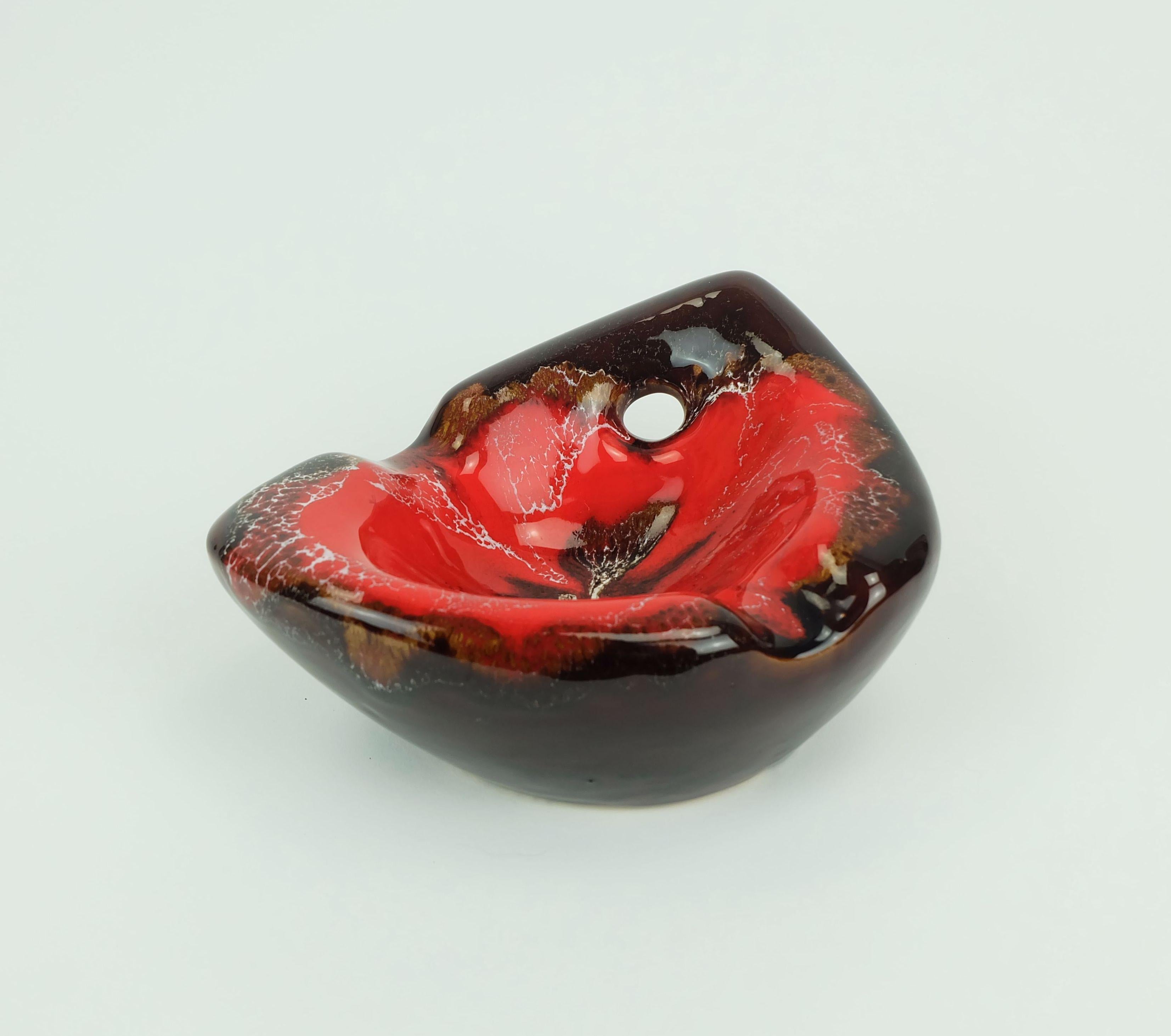 Ciotola decorativa in ceramica francese degli anni '60-'70, realizzata a Vallauris. Smalto a goccia nei toni intensi del rosso e del marrone. Forma organica.

Dimensioni in cm:
Lunghezza 19 cm, larghezza 15 cm, altezza 10 cm.

Dimensioni in