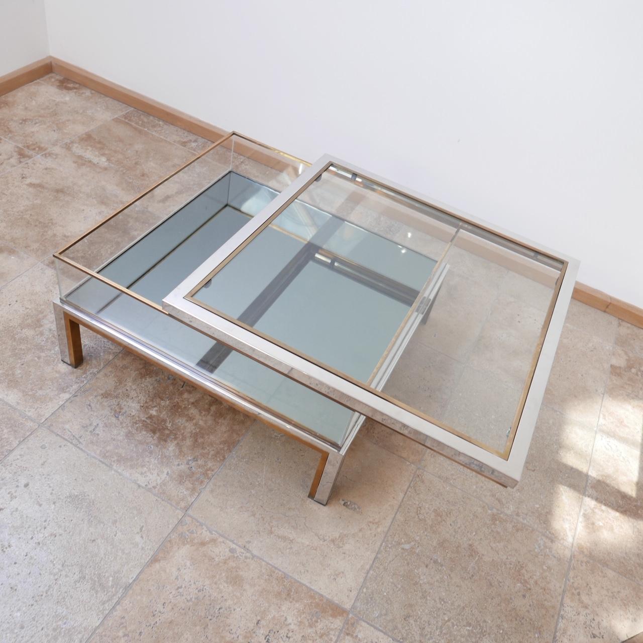 A midcentury coffee table, with glass top and mirrored base.

Two-tone metal.

Sliding door top and Perspex sides.
 