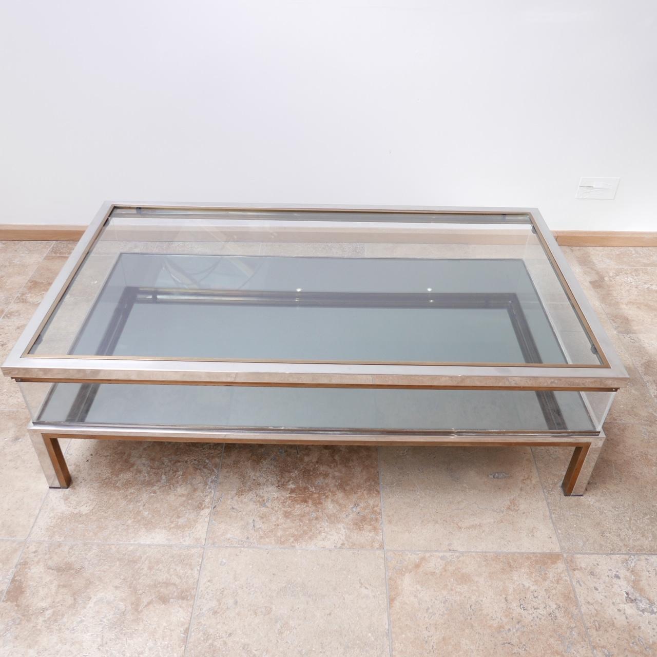 A midcentury coffee table, with glass top and mirrored base. 

Two-tone metal. 

Sliding door top and perspex sides. 

Very good condition however there is a hairline crack to one of the smaller sides of perspex (see photos).

 