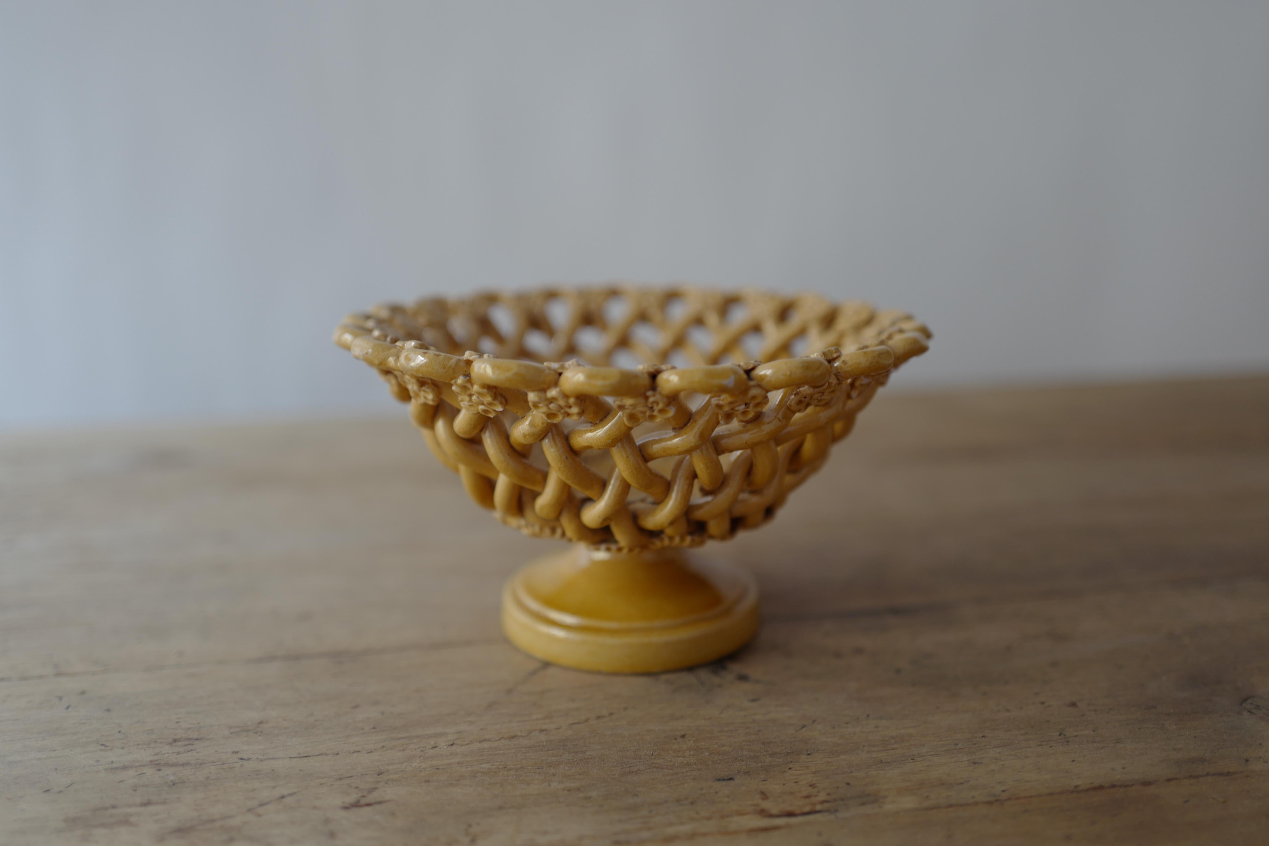 A beautiful midcentury circa 1960's French faience woven ceramic fruit bowl by Pichon a Uzes in an earthy yellow hue. Handcrafted with braided design typical of ceramic artist Pichon’s work executed in mixed earth clays. Signed. The Pichon family