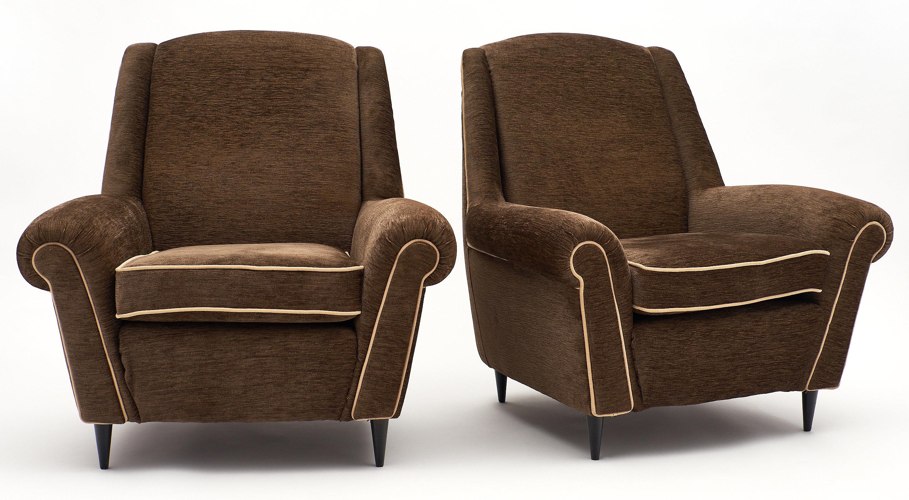 A comfortable pair of midcentury French modernist armchairs, featuring a dark top Mohair velvet mix upholstery with ivory piping. We love the tapered wooden legs, adding an elegant touch to these comfortable chairs.