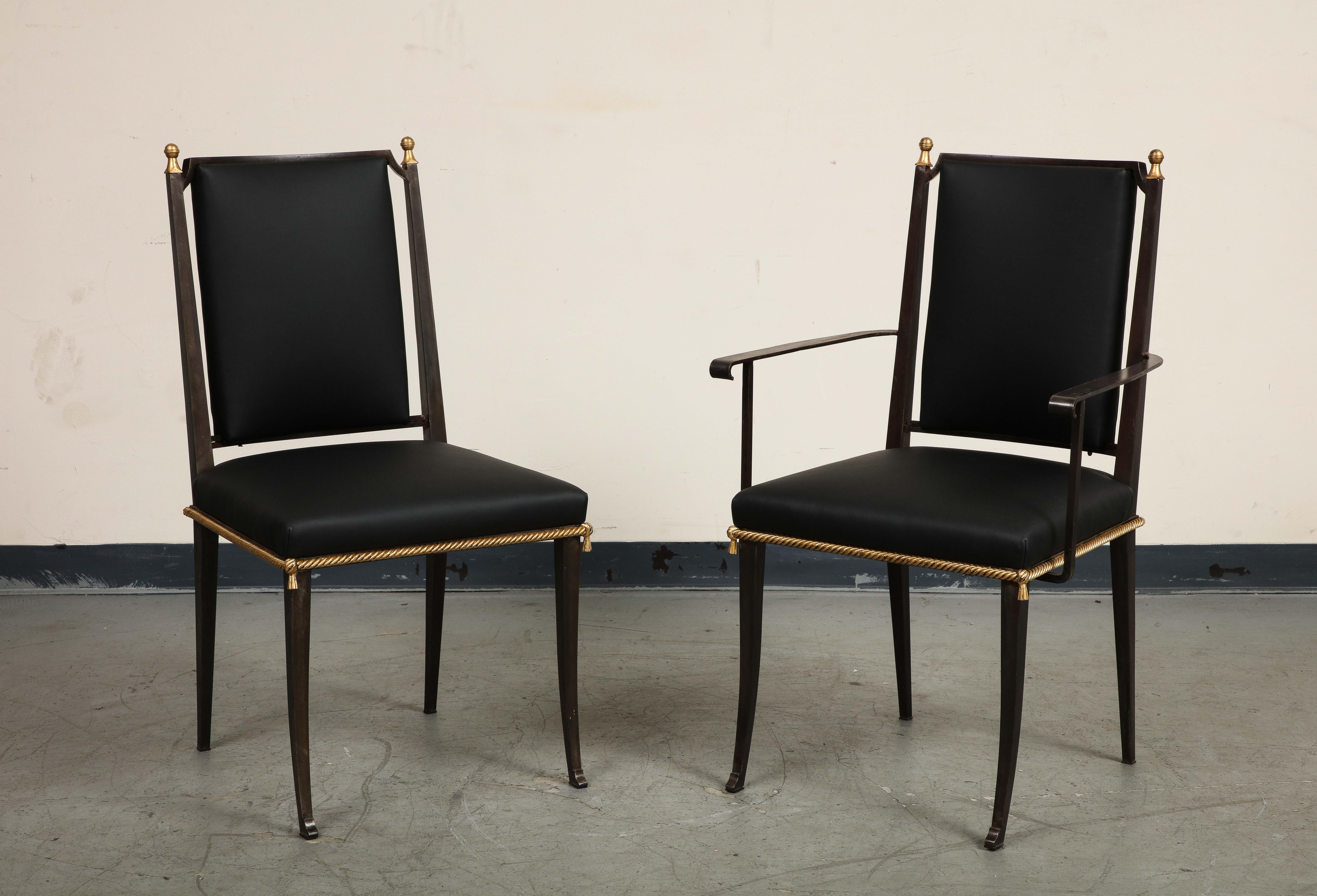 Set of 6 midcentury French dining chairs with blackened iron frames and new black leather upholstery. Gilt highlights include a cord-shaped trim around the seat, the button at the center of the x-back, and finials at the top of the back.

Four (4)
