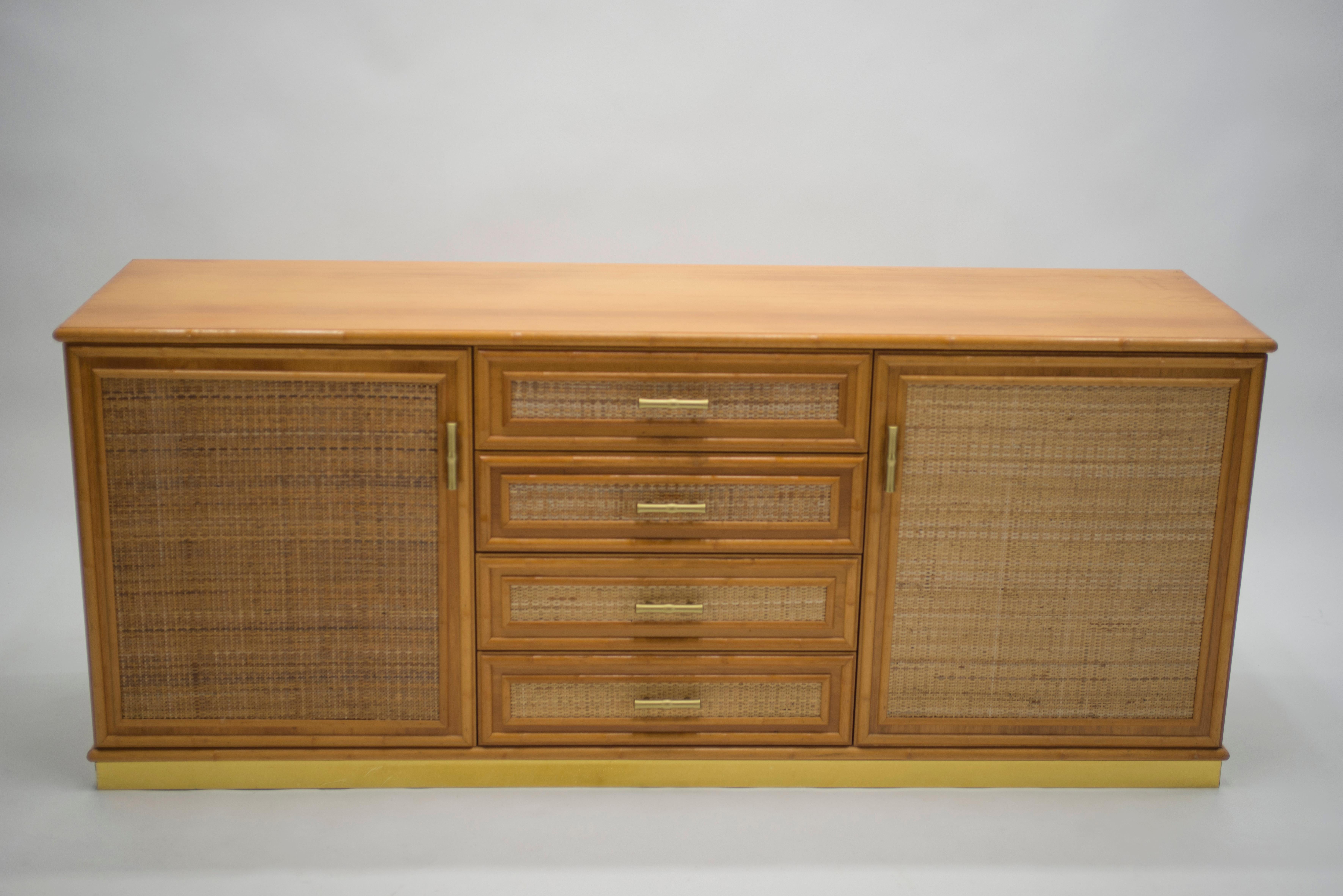 Natural bamboo as the chief material creates a summery, organic aesthetic in this 1970s sideboard, while a bright brass base and accents are strong, eye-catching touches. In particular, the brass handles on the drawers and doors are lovely examples