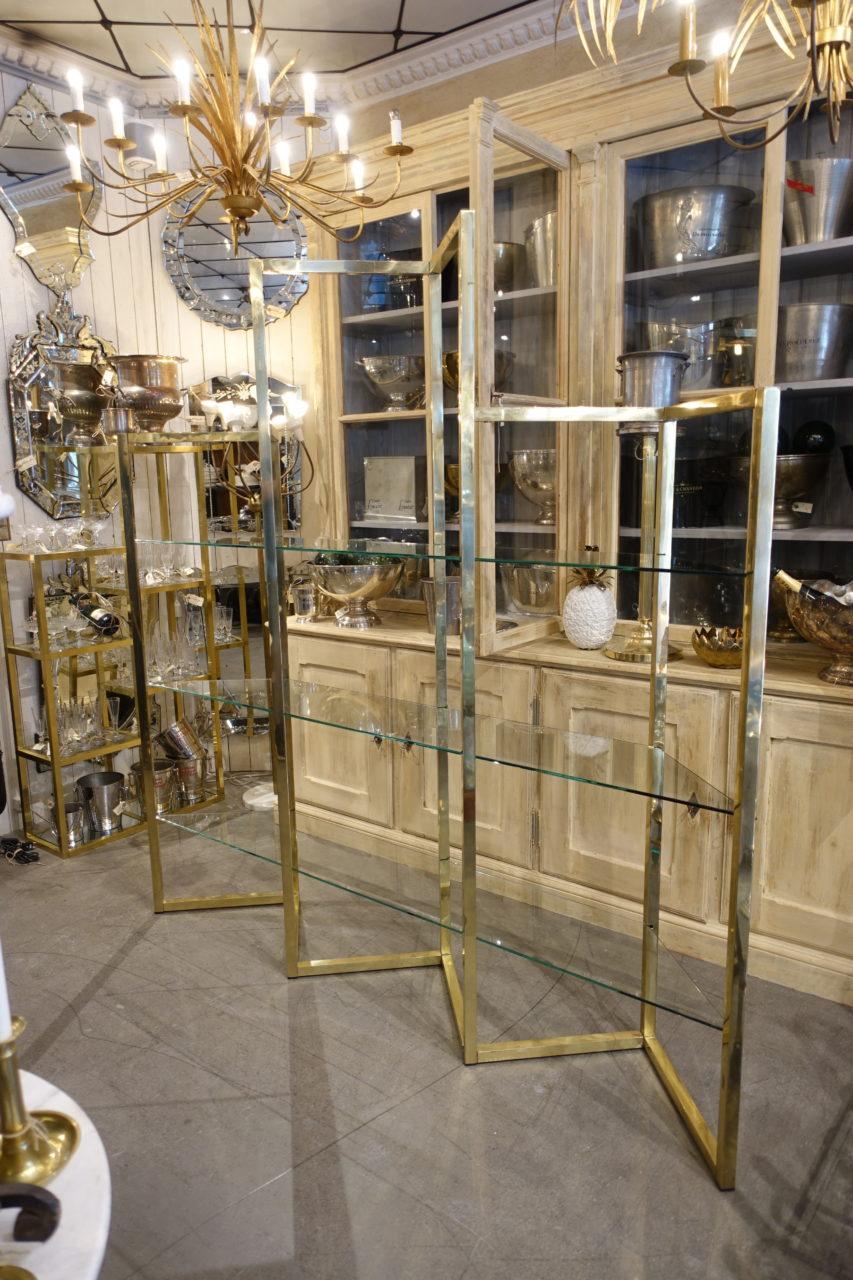 Large, handsome distinctive and sculptural vintage brass shelves, from 1960s, France. With elongated glass shelves, divided into 3 triangular high sections with two lower units, one on each side and one higher part in the middle. Together they form