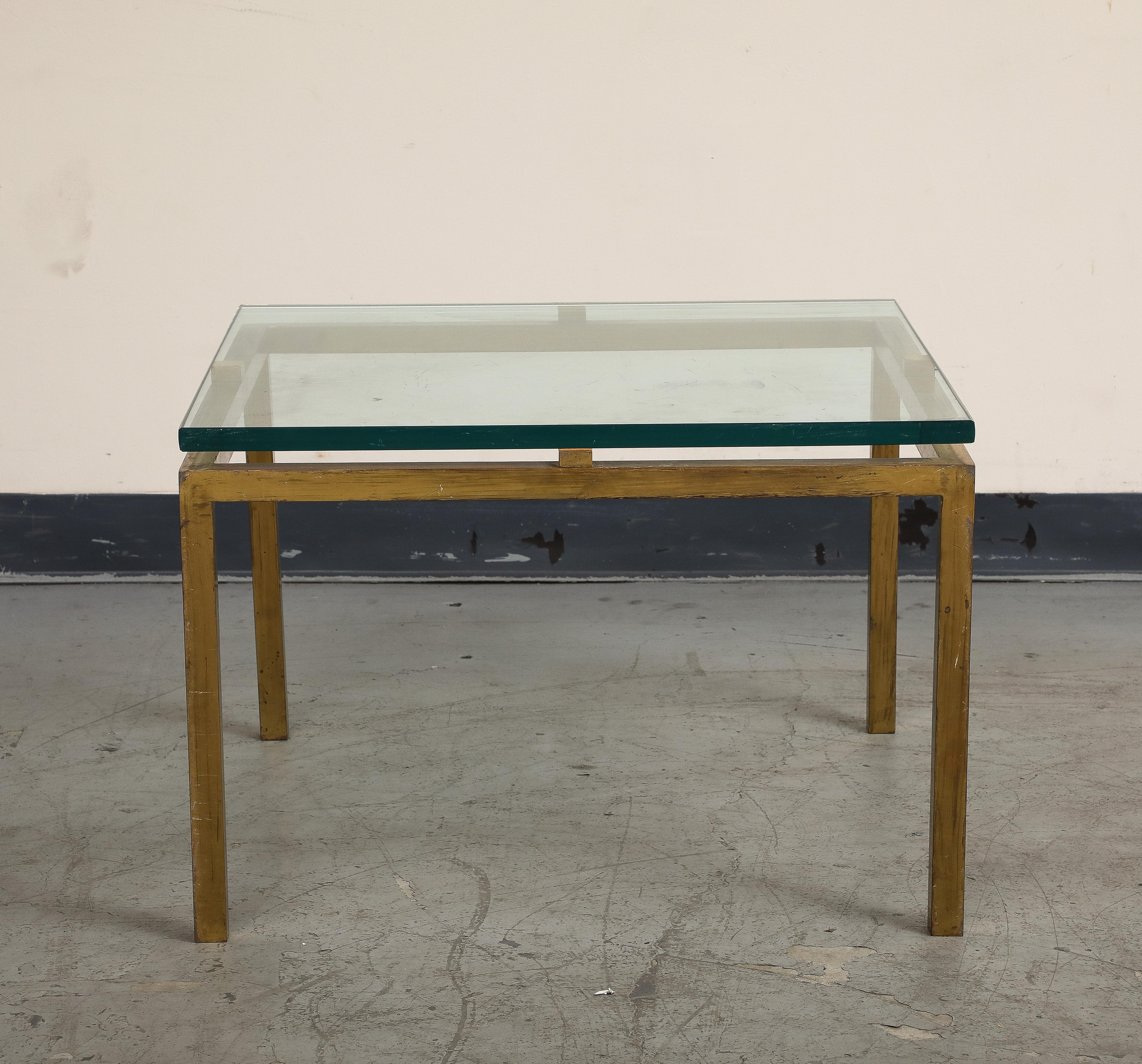 Midcentury French brass and glass side table, 1970s. The glass top is slightly elevated to accentuate the full square brass base. 