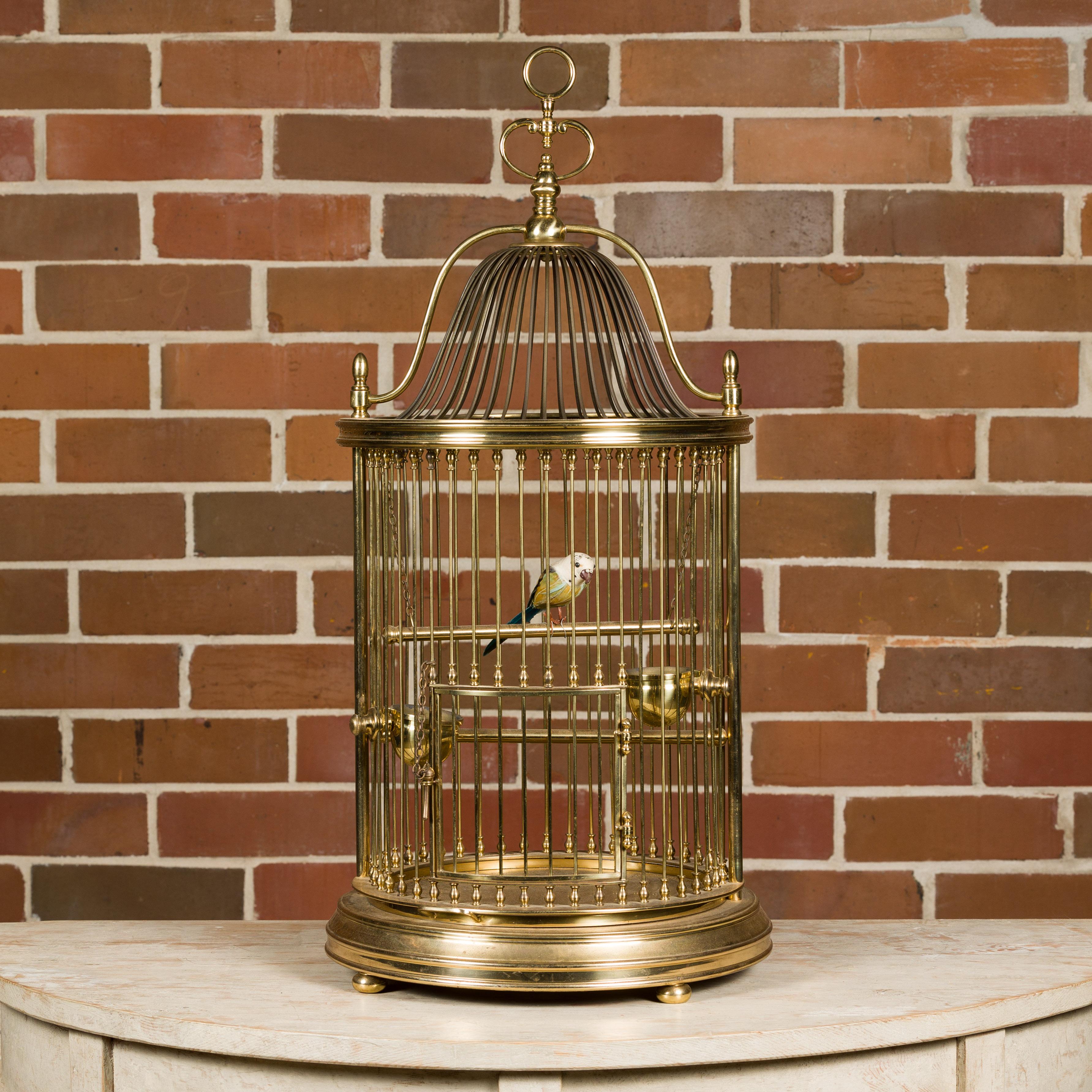 This French brass circular birdcage from the Midcentury period is a delightful combination of form and whimsy, perfect for adding a touch of vintage charm to any interior. Crafted with meticulous attention to detail, this birdcage features a lovely
