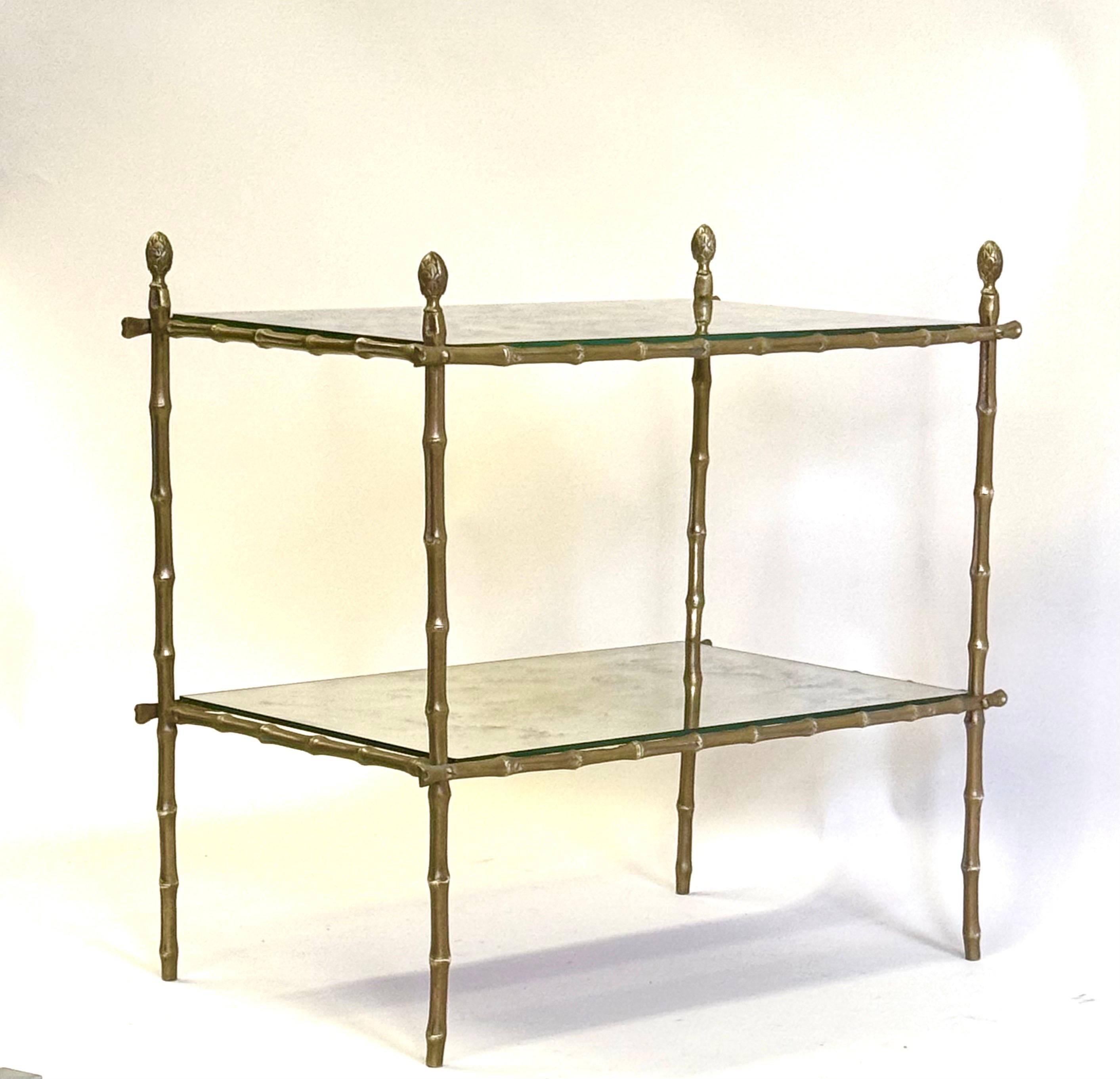 Elégante et intemporelle table d'appoint ou table basse à deux niveaux, en laiton, faux bambou et miroir patiné, de style néoclassique français du milieu du siècle, par la Maison Bagues, Paris, France, vers 1950 - 1960. La pièce présente une forme