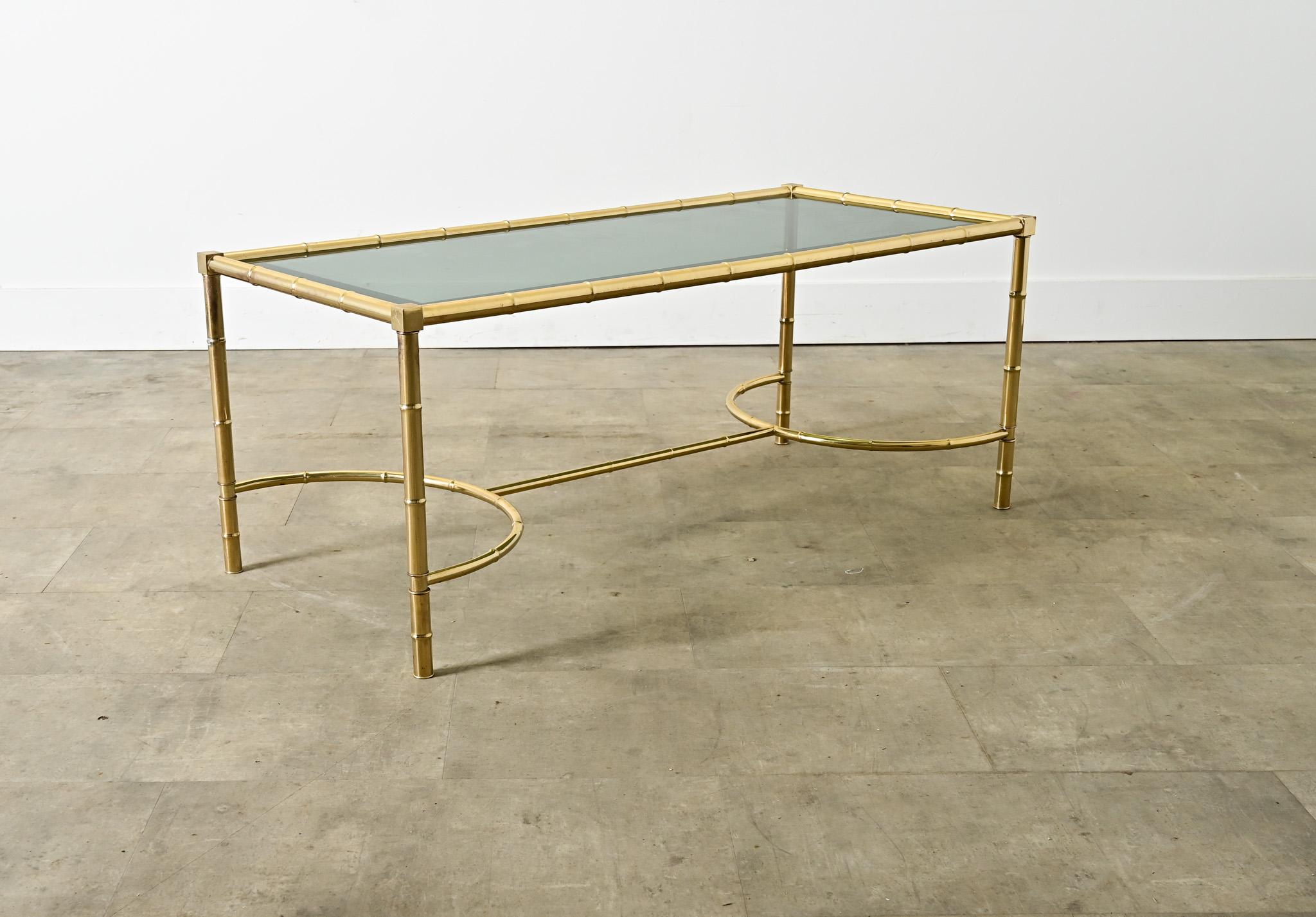 Cette table à café et à cocktail en faux bambou, fabriquée en France au milieu du siècle dernier à la manière des légendes du design que sont la Maison Baguès et Jansen, est une combinaison de laiton et de verre de style Hollywood Regency qui