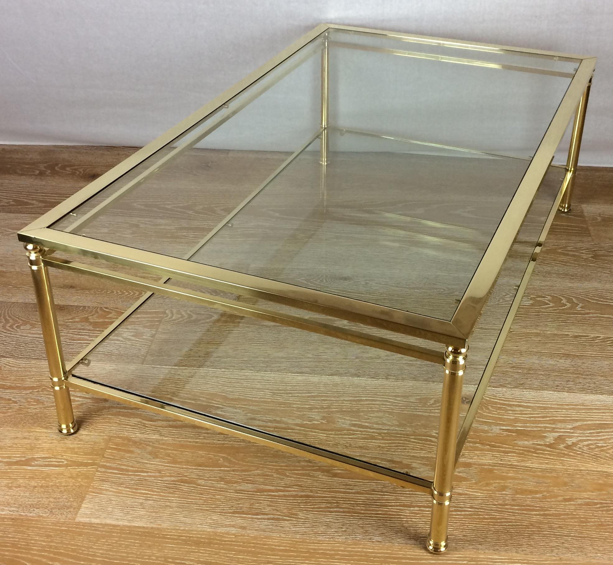 Elegant French Mid-Century Modern coffee or cocktail table in solid brass attributed to Maison Jansen.
Two-tiered, in perfect condition. 

    